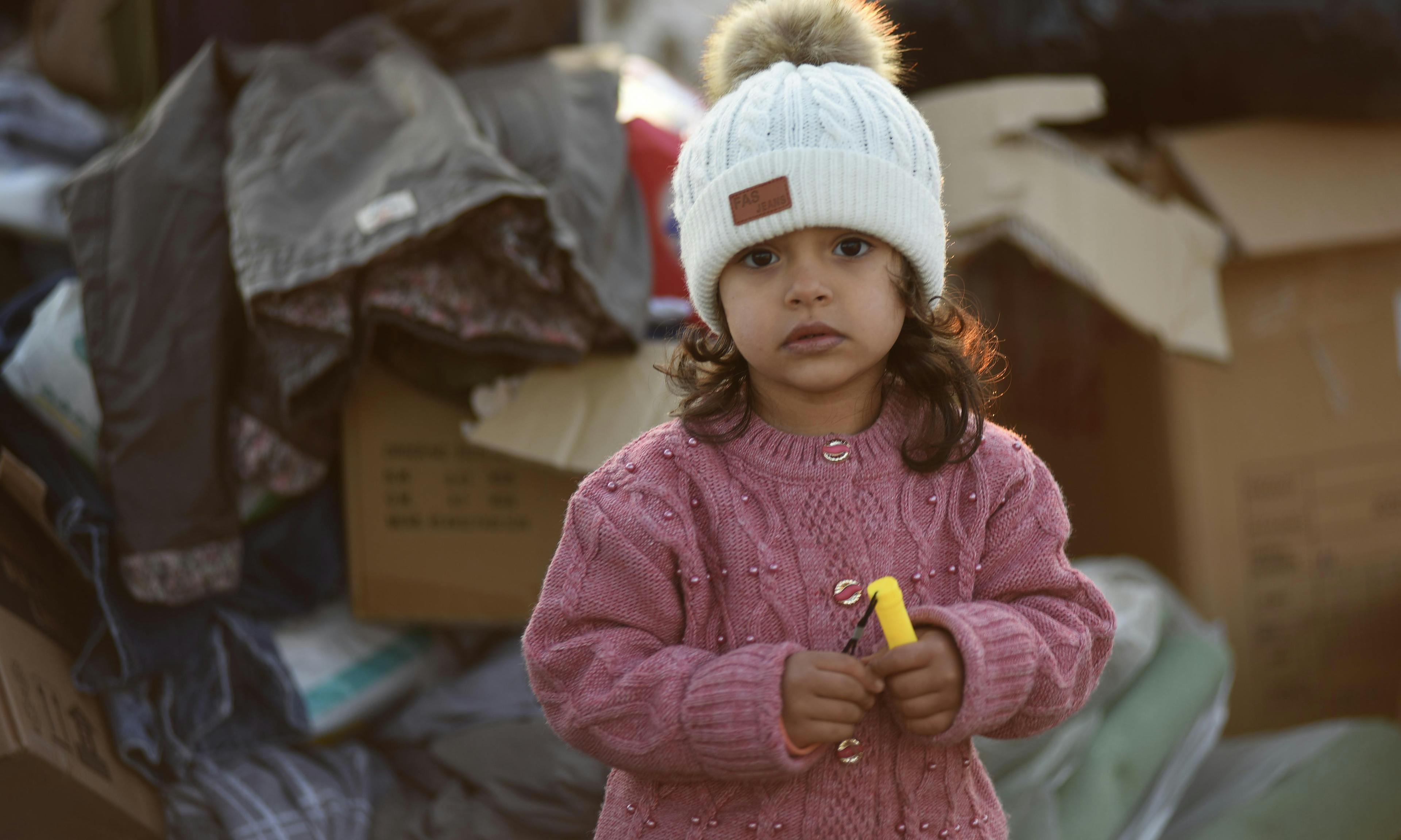 A little girl stands amongst the boxes of supplies sent to the survivors of the 7.7 magnitude earthquake in Kahramanmaraş, Türkiye.