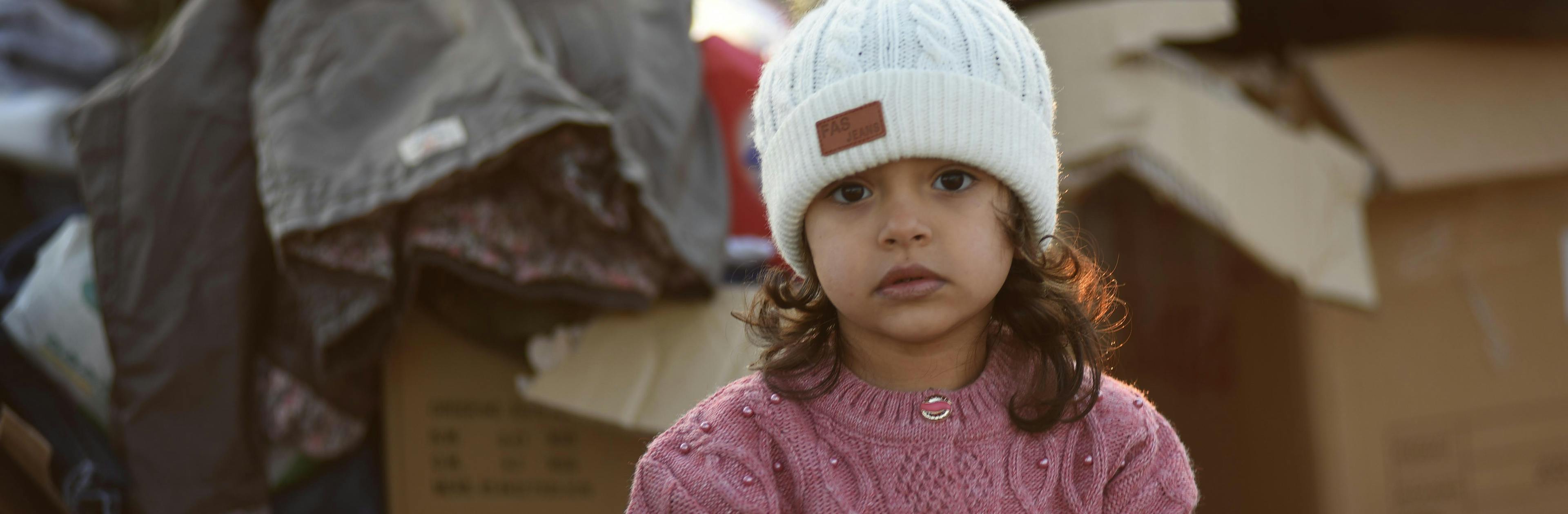 A little girl stands amongst the boxes of supplies sent to the survivors of the 7.7 magnitude earthquake in Kahramanmaraş, Türkiye.