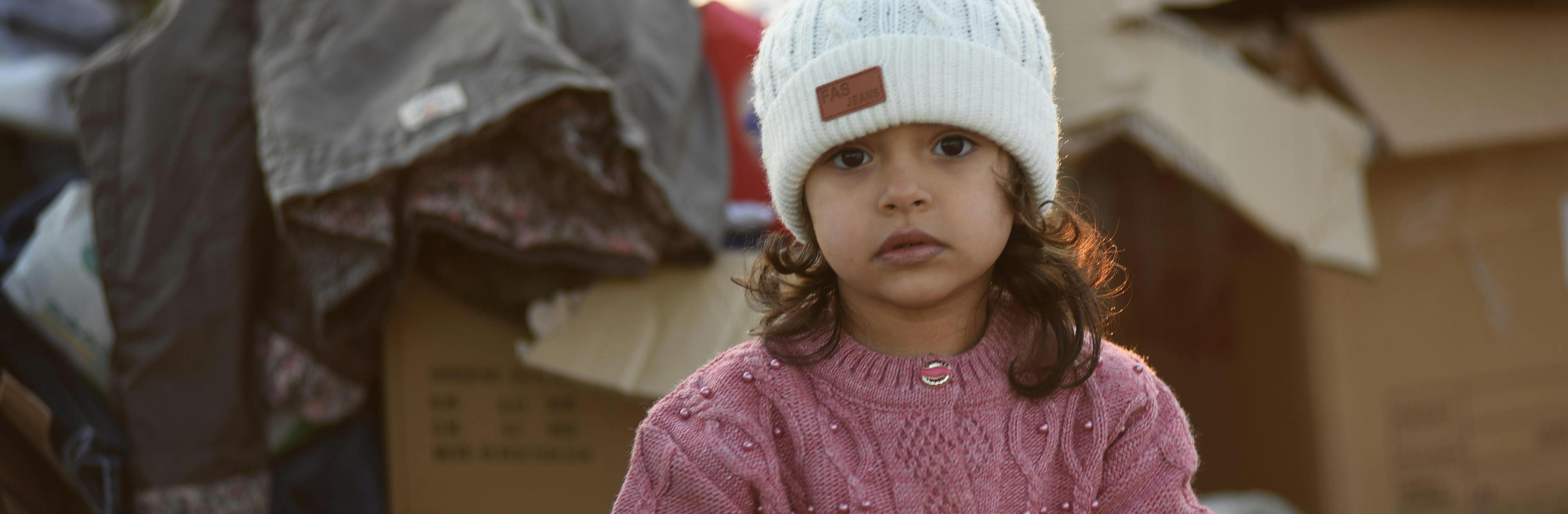 A little girl stands amongst the boxes of supplies sent to the survivors of the 7.7 magnitude earthquake in Kahramanmaraş, Türkiye.