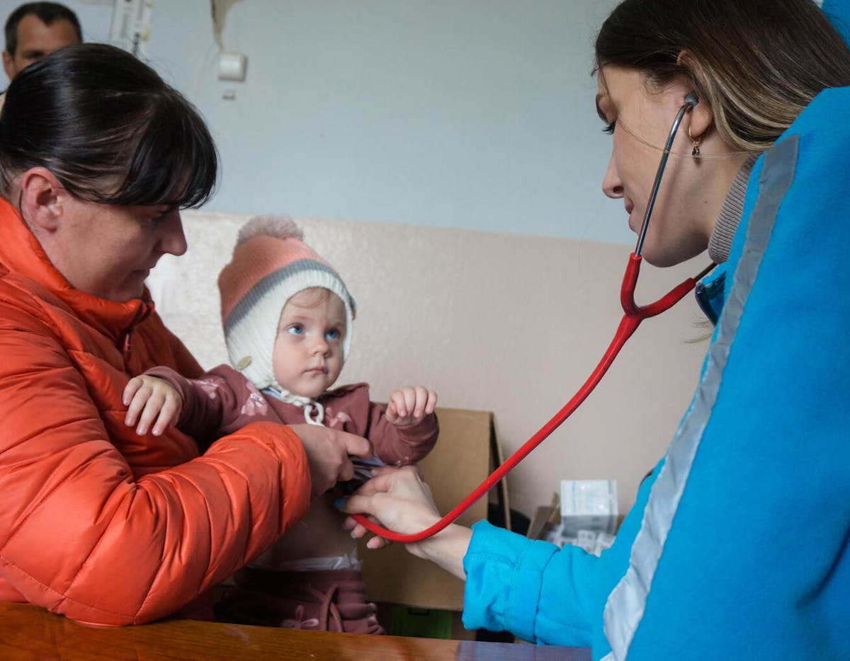 Global Parent- Doctor of the UNICEF mobile medical team Alina Velychko listens to the lungs of one-year-old Yevheniya.