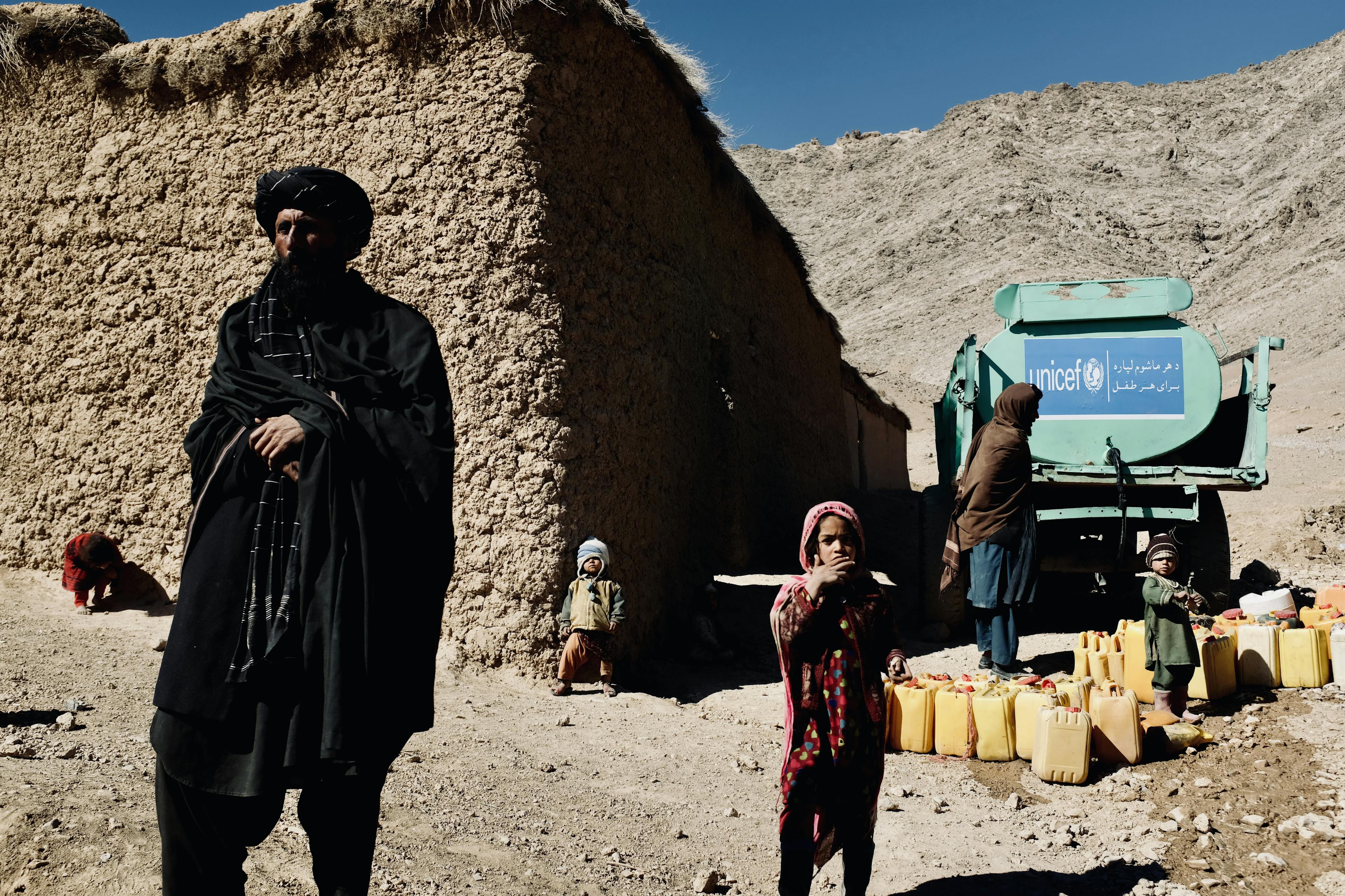 55-year-old Najeeb (left) and his 4 children by their house and UNICEF water truck. The family lost 3 children to drought.