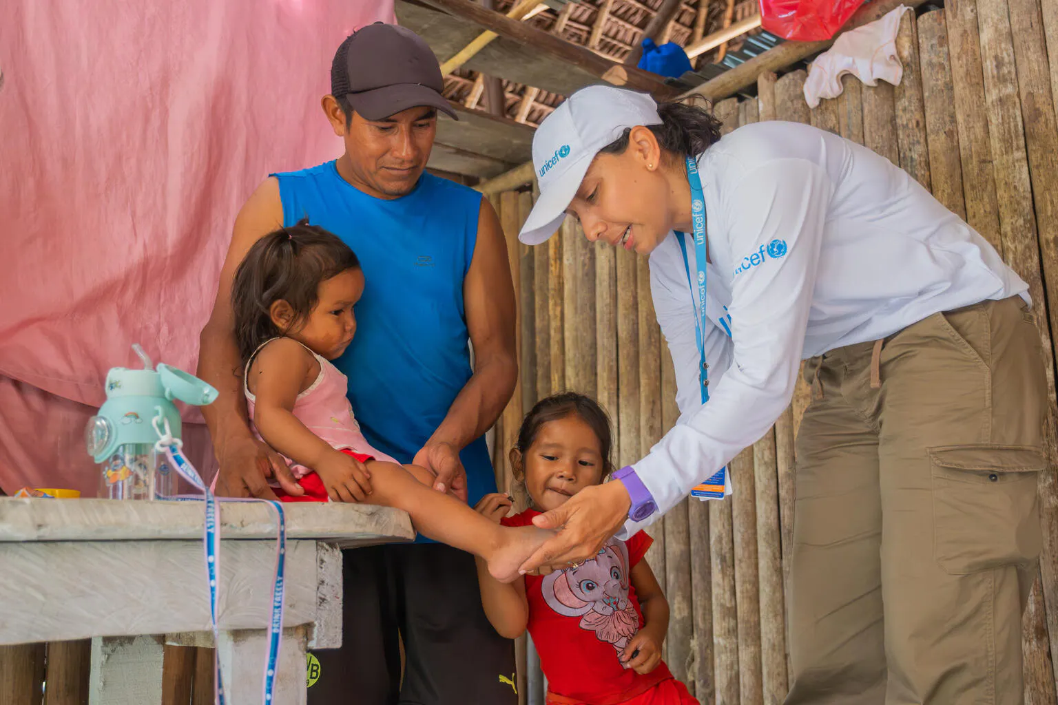 Salomé and Judith, 1 and 3 years old, receive a home visit from UNICEF and the community health worker to assess their nutritional status.