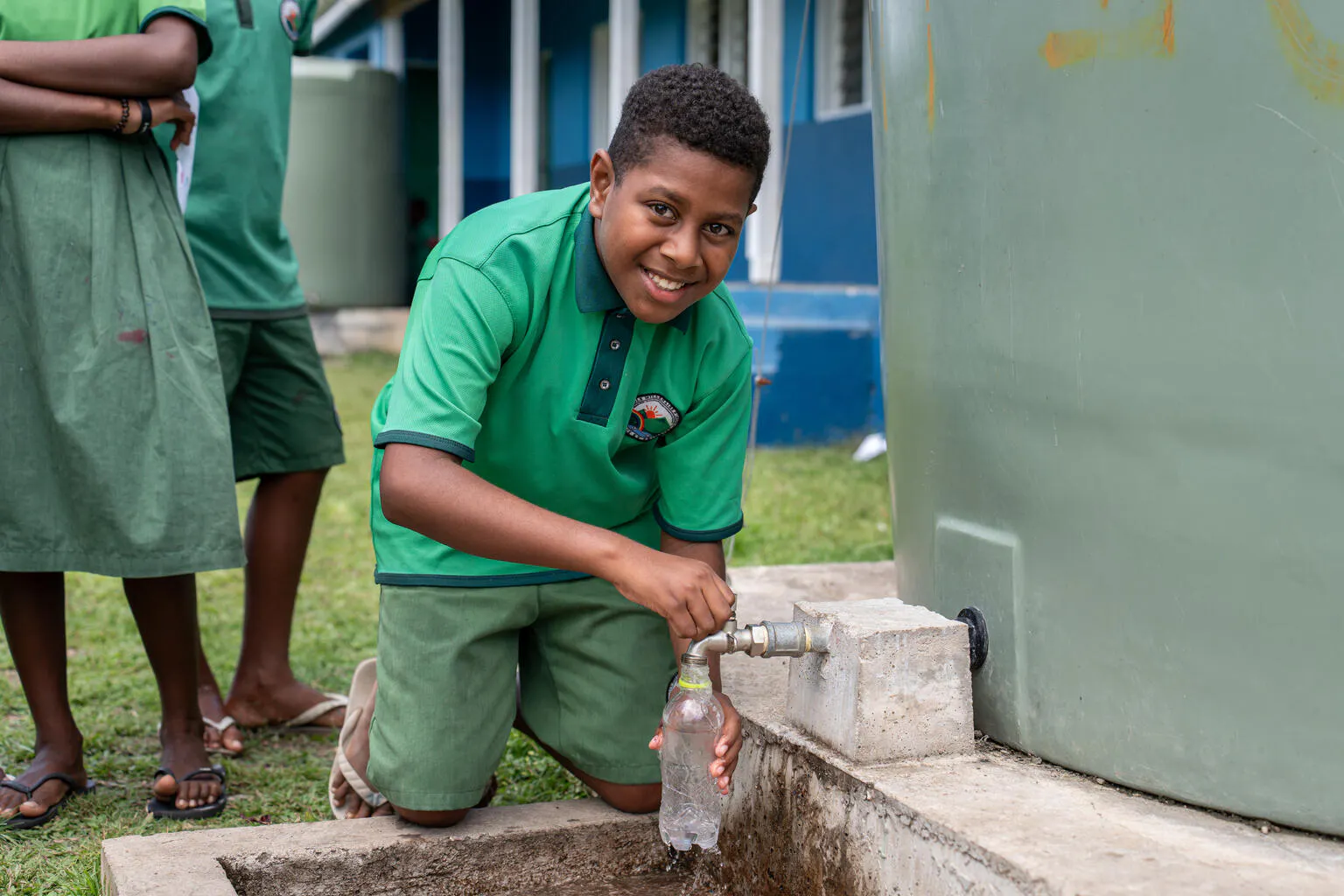 A student filling his bottle at the UNICEF-installed water tank with support from The Church of Jesus Christ of Latter-day Saints, showing the importance of hygiene and safe water access. Suango School, Mele, Efate, SHEFA, Vanuatu.