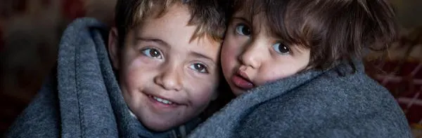 Hakim and Amira wrapped up in blanked inside the family tent in the Domiz refugee camp in Northern Iraq.