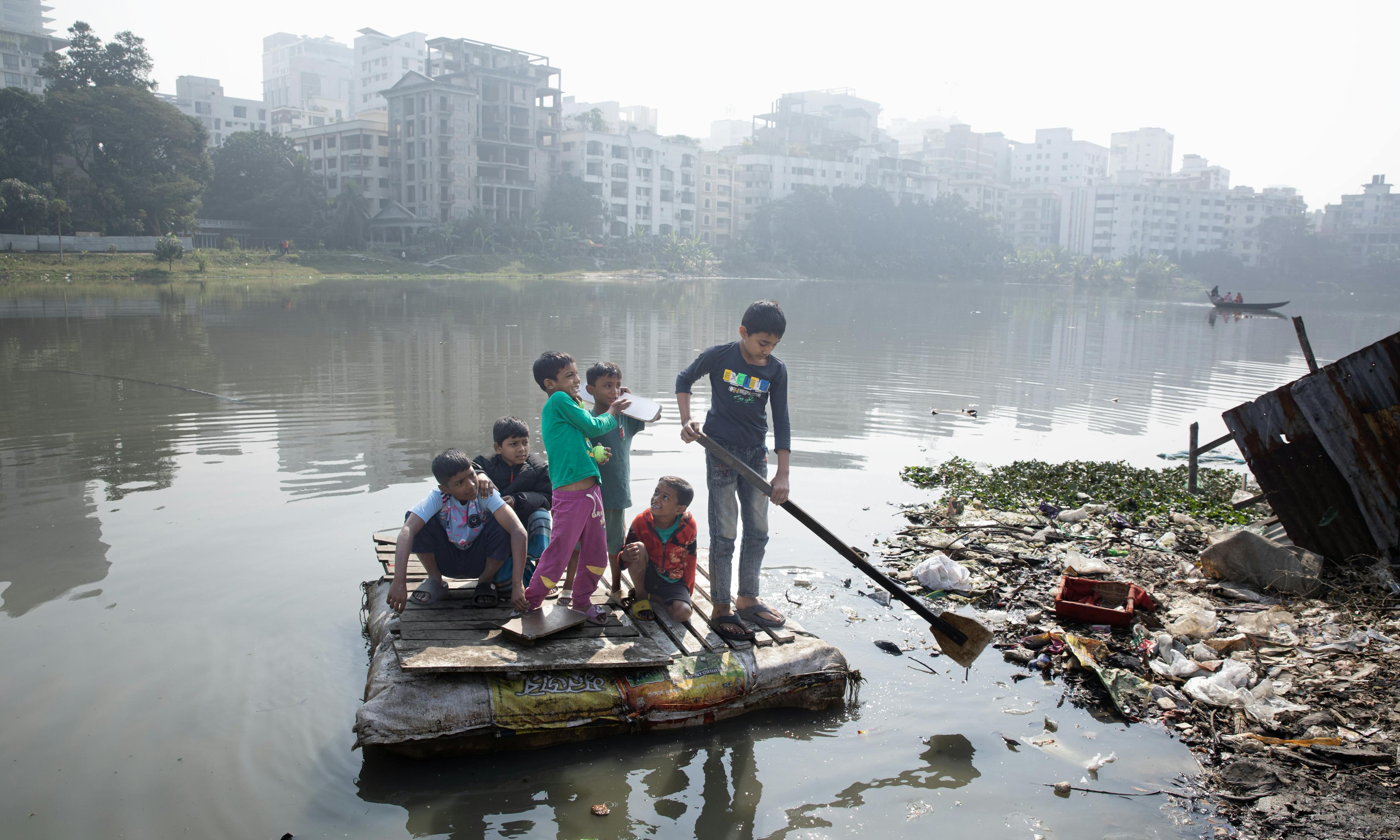 Children are having fun on a raft, after winning their cricket match, on the polluted Banani Lake in the Korail Slum of Dhaka, Bangladesh, on 28 January 2024