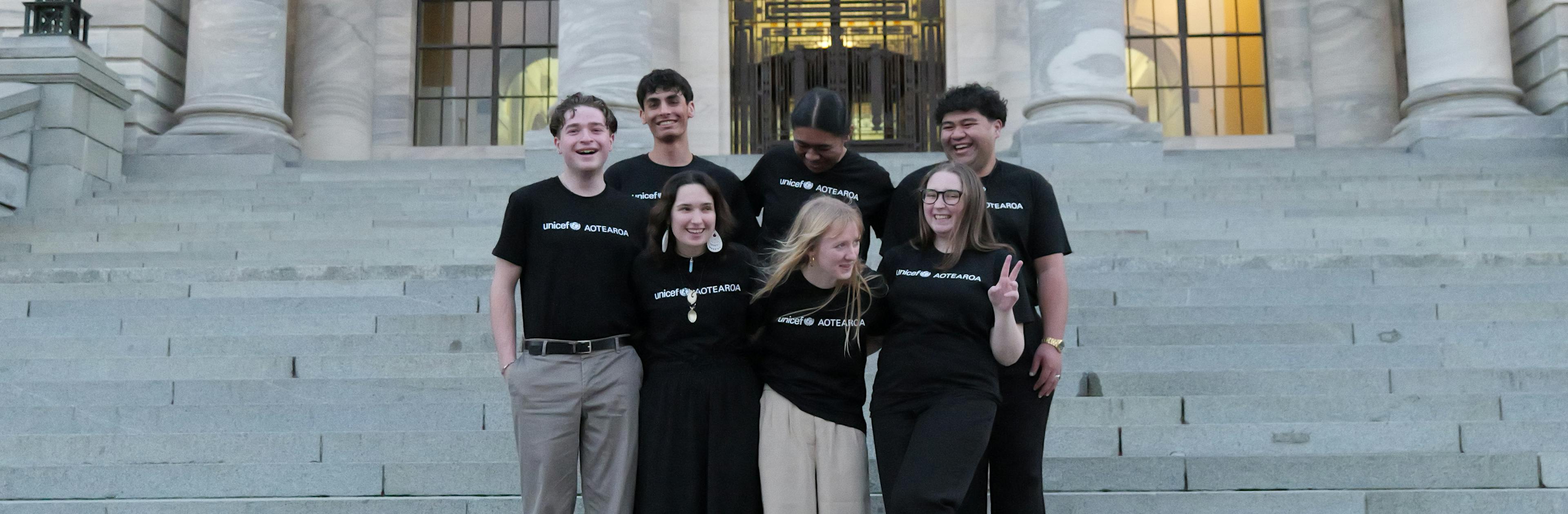 The 2024 UNICEF Aotearoa Young Ambassadors standing outside New Zealand's parliament.