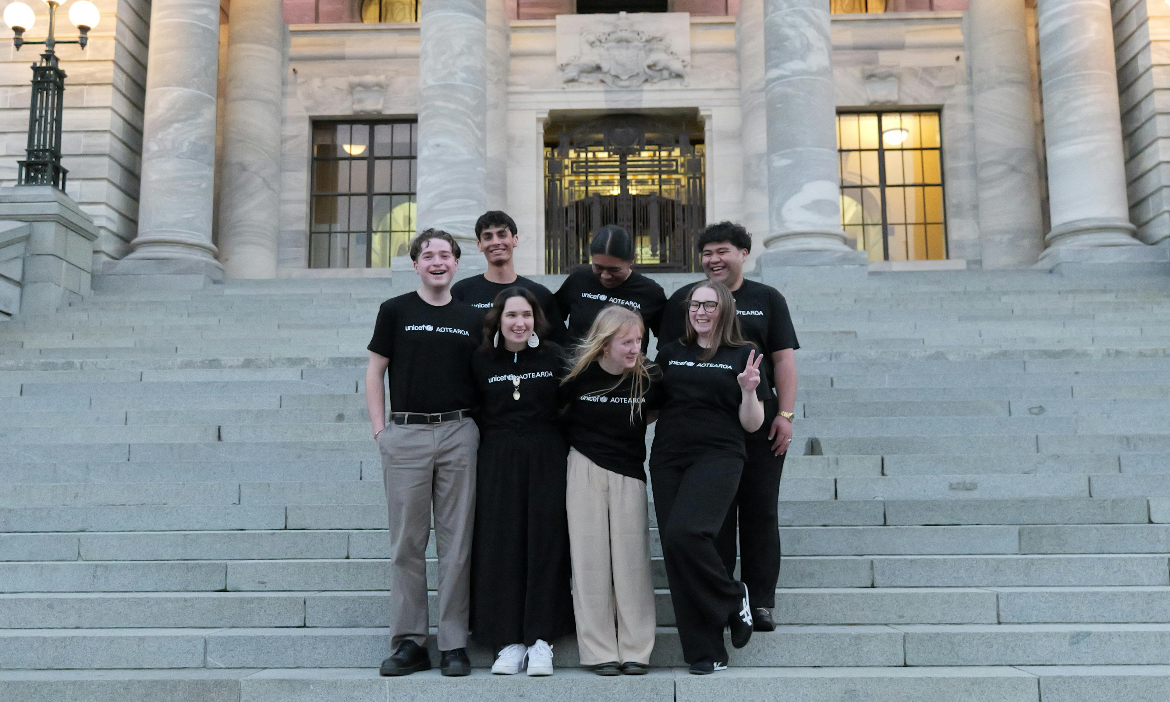 The 2024 UNICEF Aotearoa Young Ambassadors standing outside New Zealand's parliament.