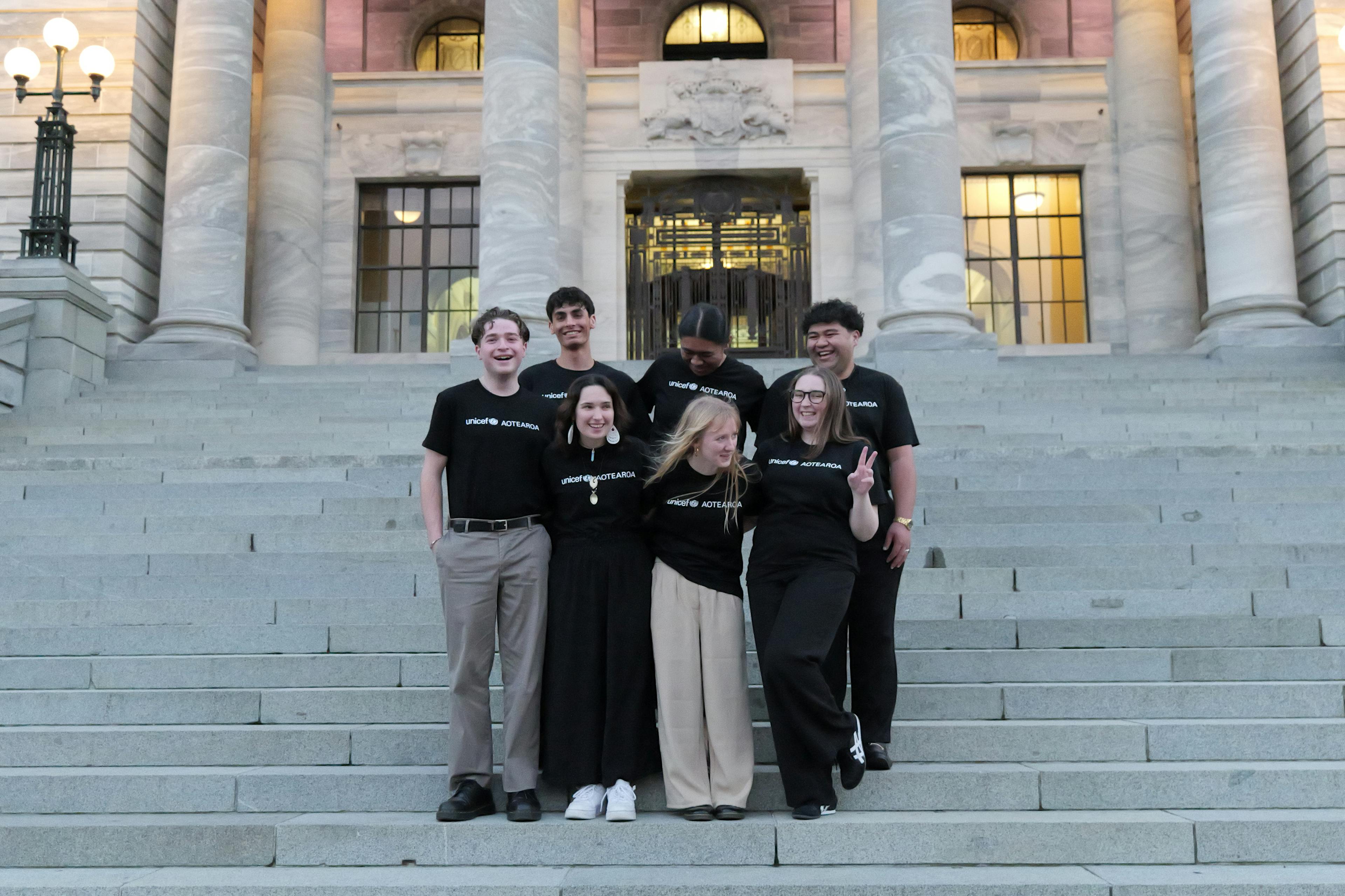 The 2024 UNICEF Aotearoa Young Ambassadors standing outside New Zealand's parliament.