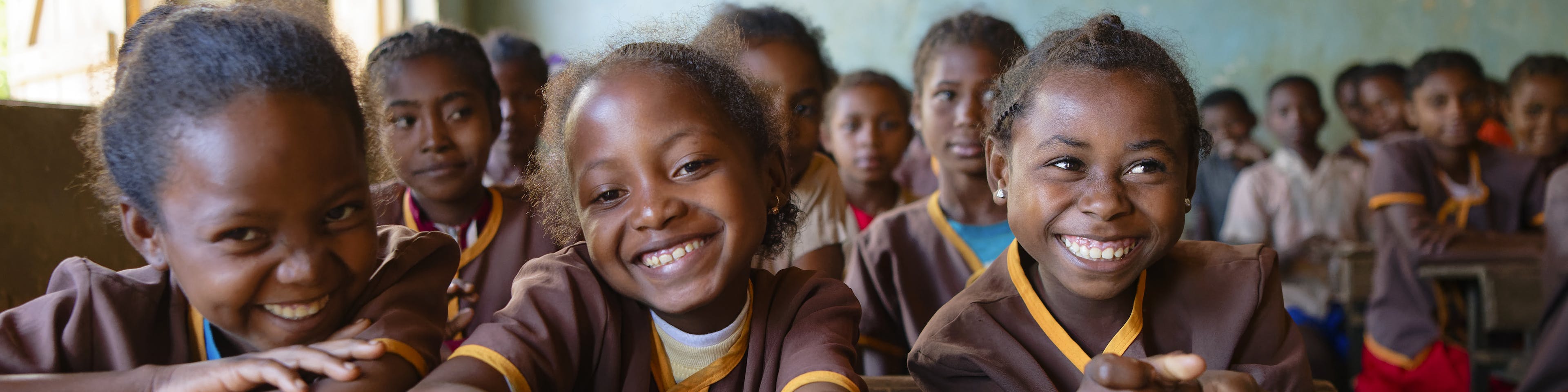 A group photo of smiling schoolgirls in their classroom at Mahatsara Sud Primary Public School, Mananjary District, Vatovavy Region, Madagascar