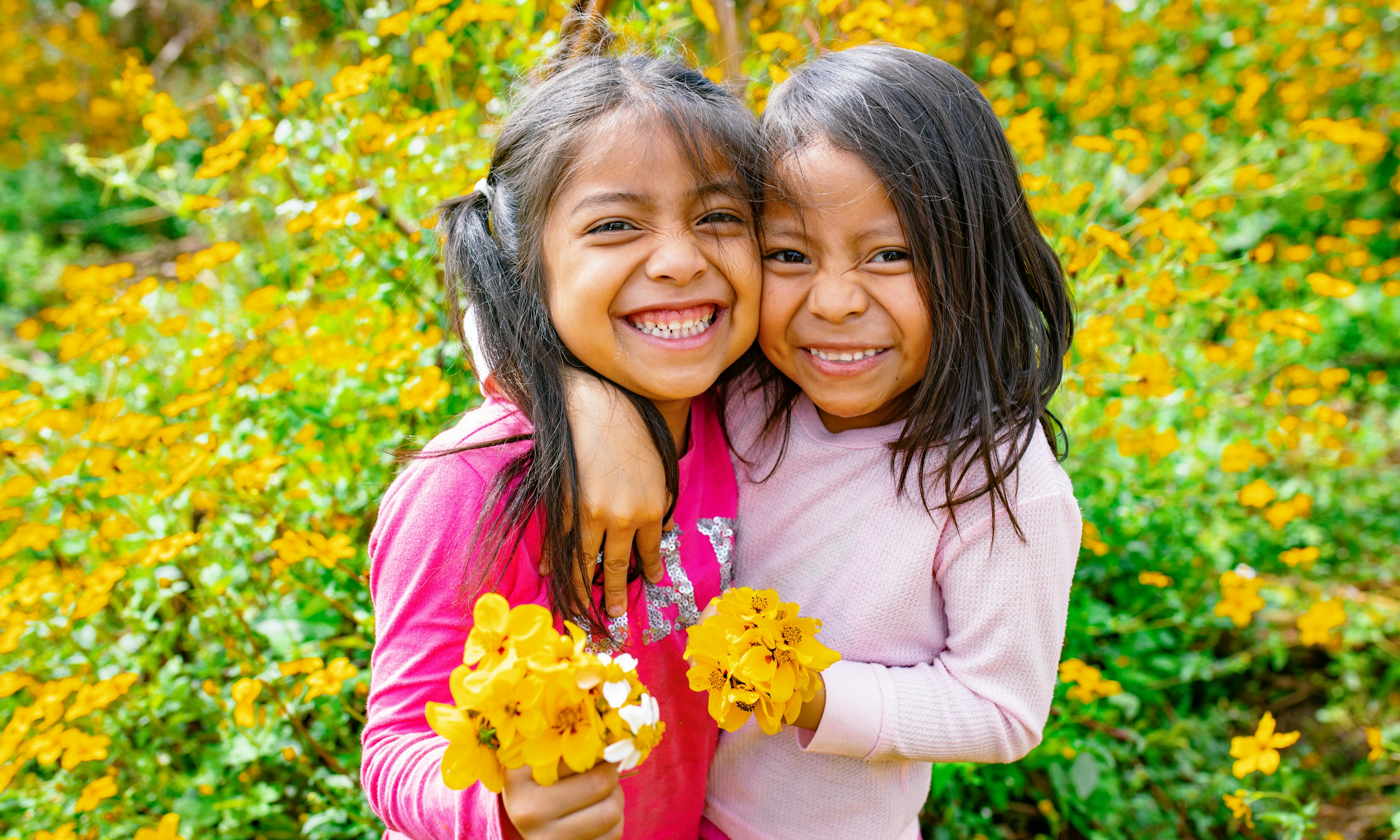 Genesis Alvarez (5 years old) and Kiara Mejia (6 years old) walk into a field at the back of their house in Olintepeque, Quetzaltenango, Guatemala

