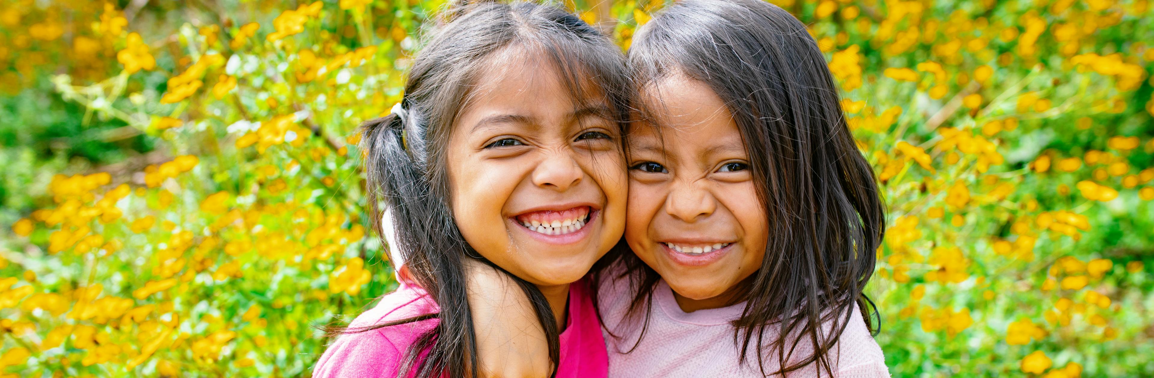 Genesis Alvarez (5 years old) and Kiara Mejia (6 years old) walk into a field at the back of their house in Olintepeque, Quetzaltenango, Guatemala

