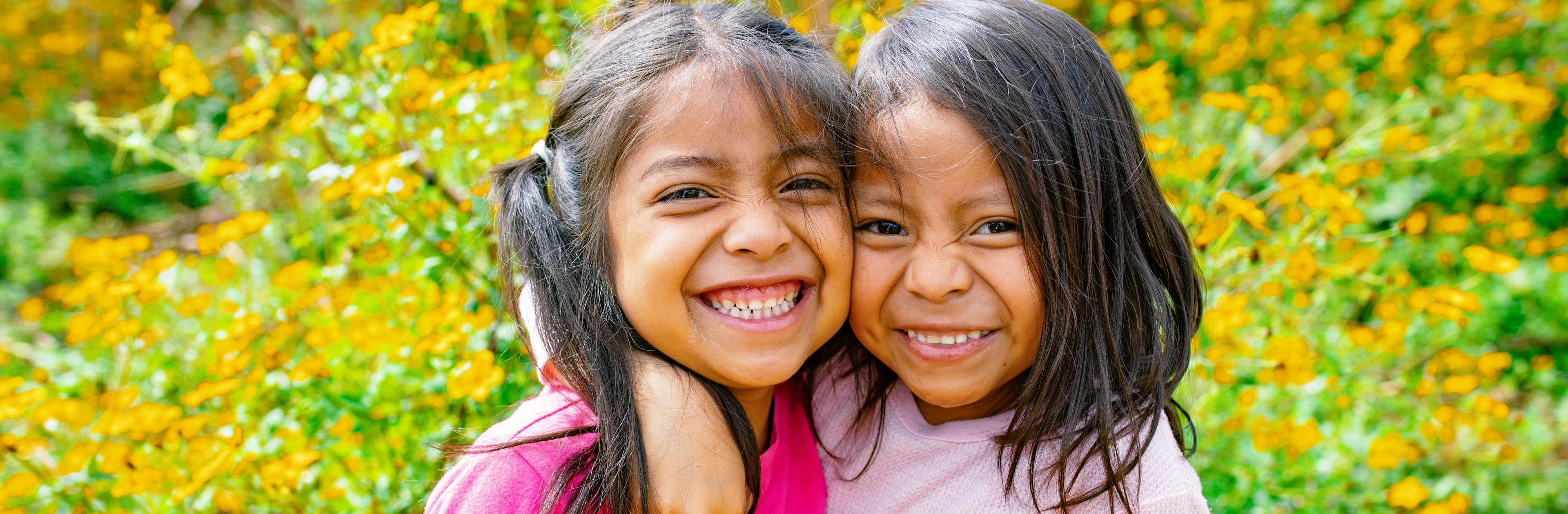 Genesis Alvarez (5 years old) and Kiara Mejia (6 years old) walk into a field at the back of their house in Olintepeque, Quetzaltenango, Guatemala