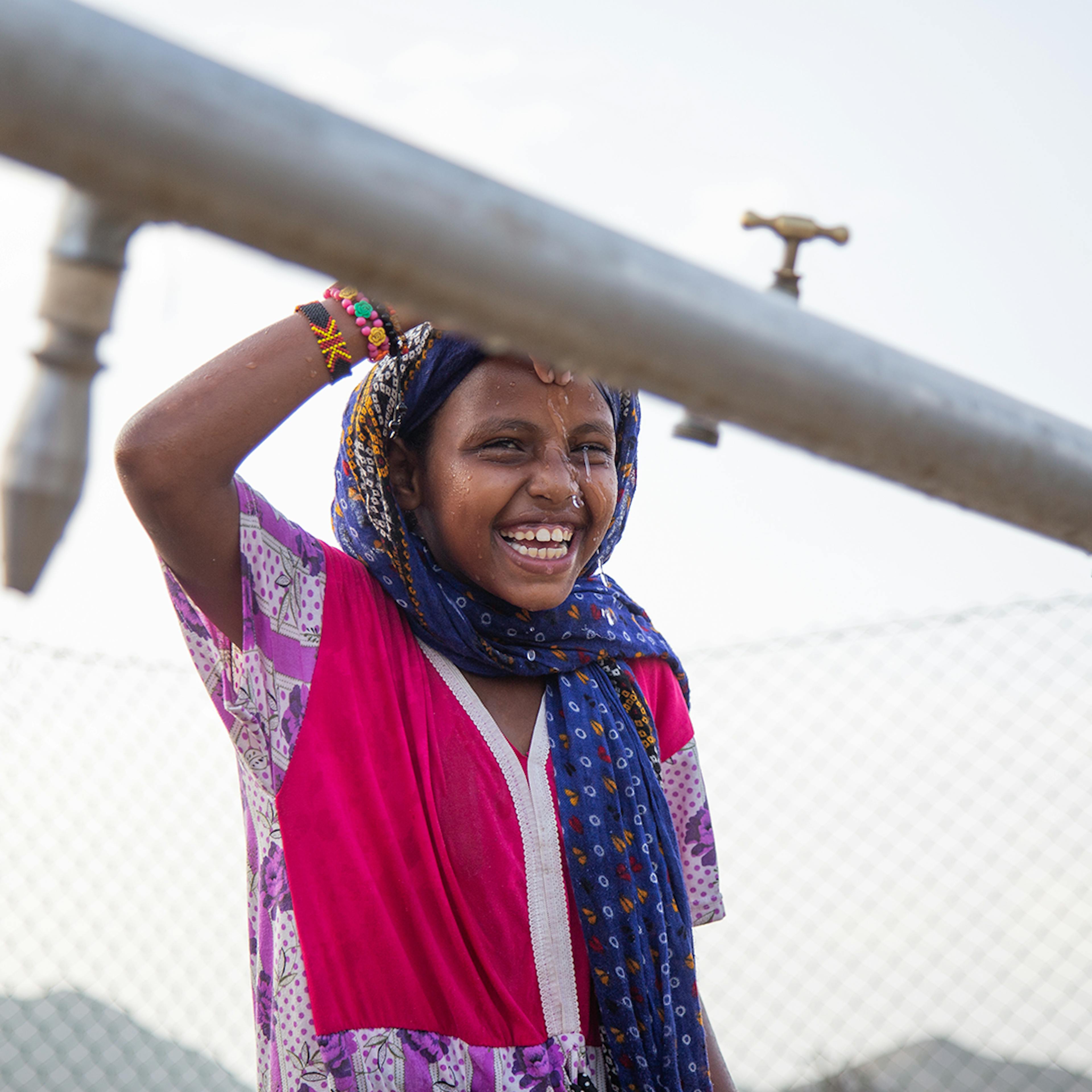 7-year-old Madina Mohamed Awad collects water at a new water station in the small village of Gelhanty in Agig locality, Red Sea state.