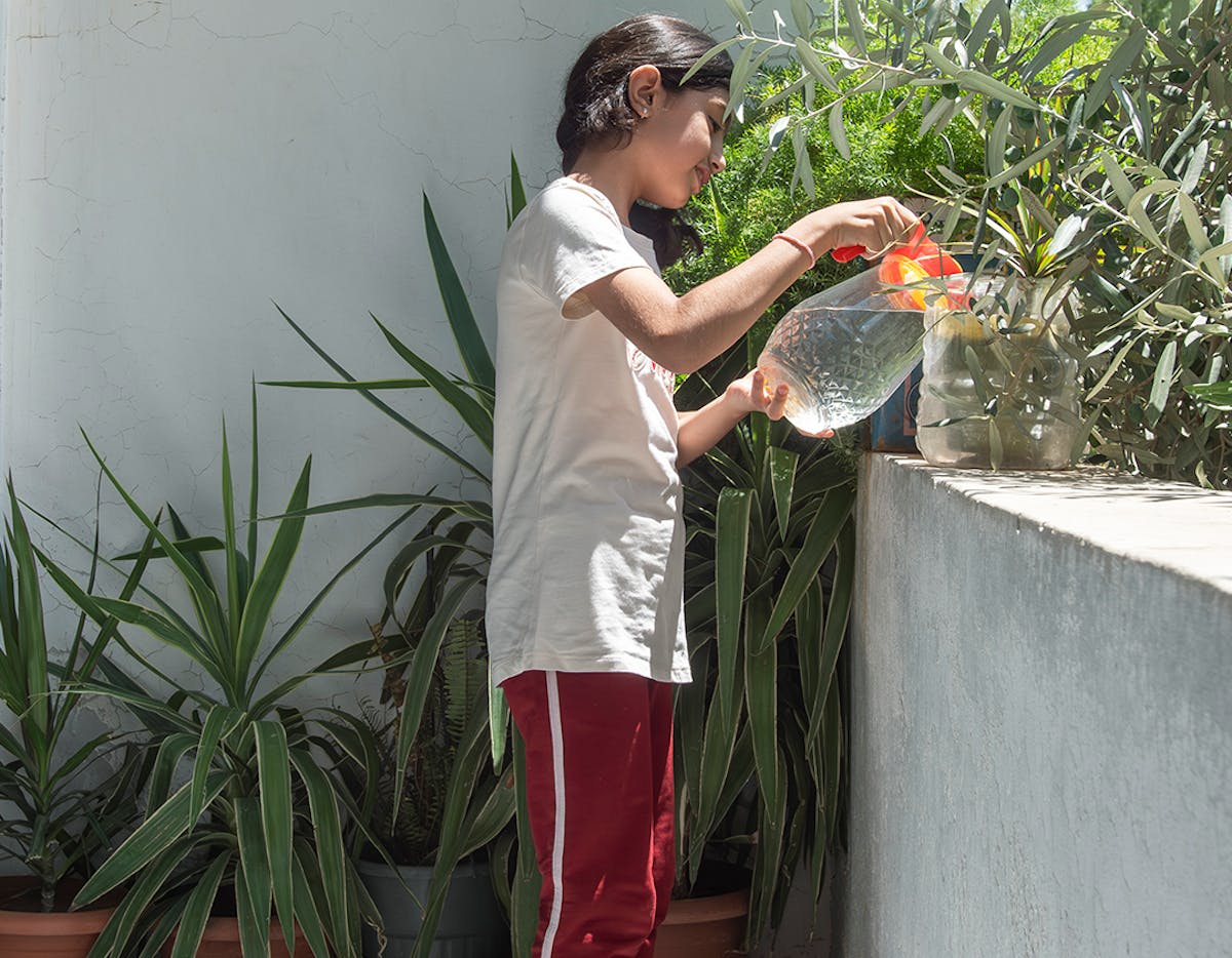 Lana, 12, Leila’s granddaughter, waters the plants on her balcony in Western gathering, Kisweh city, Rural Damascus, Syria, 25 July 2024.