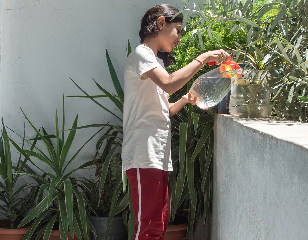 Lana, 12, Leila’s granddaughter, waters the plants on her balcony in Western gathering, Kisweh city, Rural Damascus, Syria, 25 July 2024.