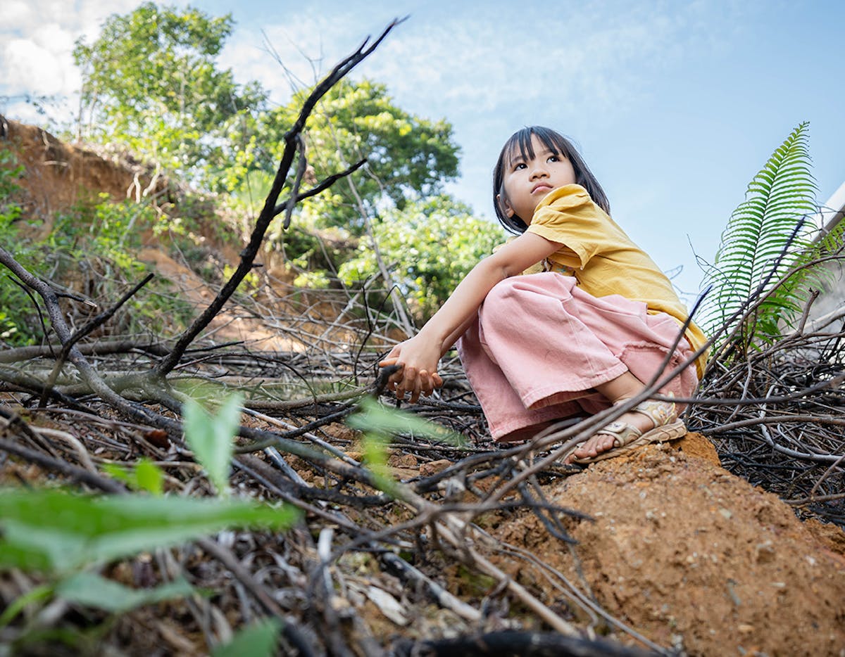 29 October 2024 - Lu Ngoc Anh, 8, sits on the debris left by a landslide triggered by Typhoon Yagi, which destroyed a wall in her family home in Muc village, Lao Cai province.