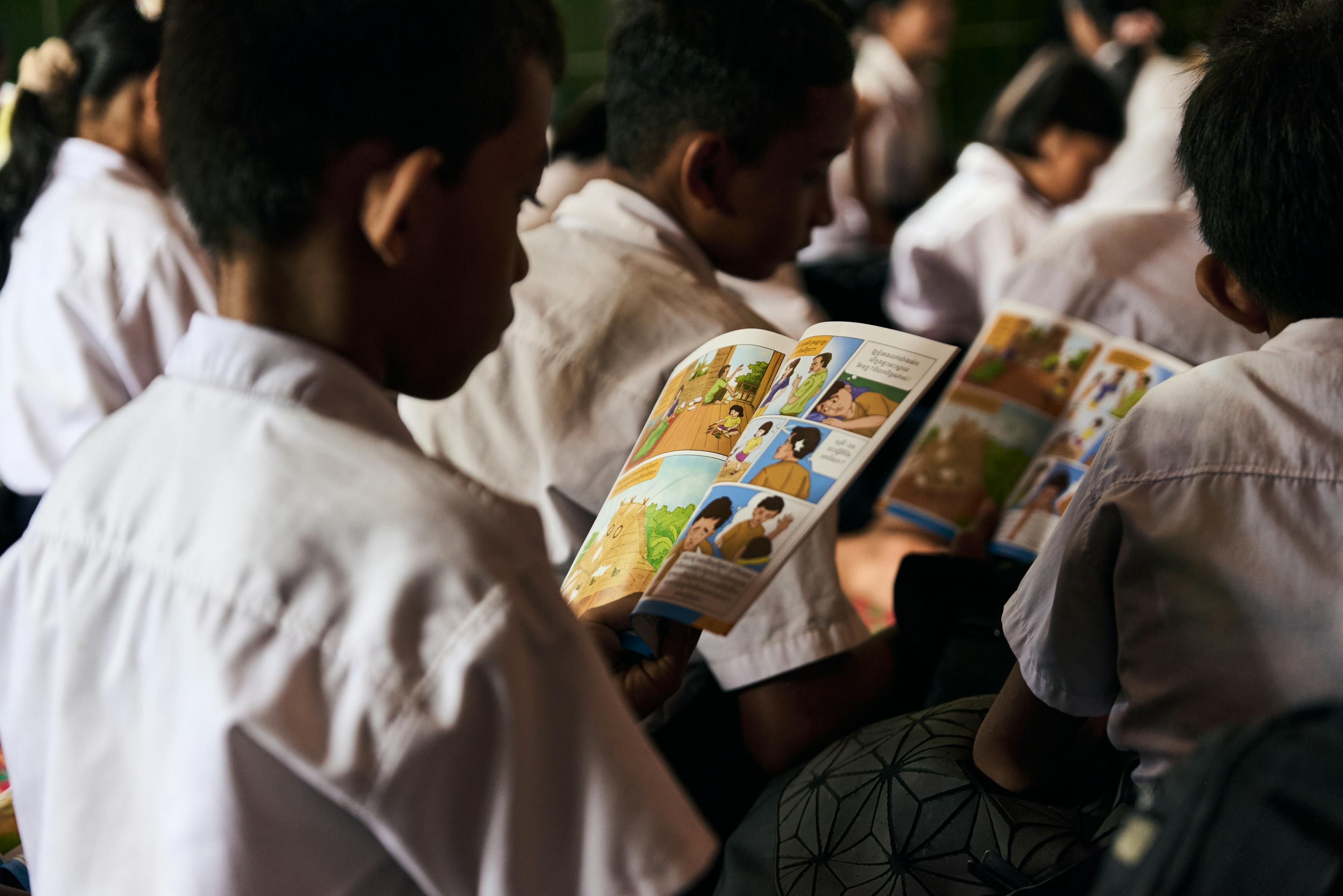 Student reading the UNICEF booklet in a UNICEF Child Protection session, which in Cambodia is led by monks. Monks in Cambodia are a very influential figure in society and so UNICEF implements training and resources for the monks to deliver the sessions.