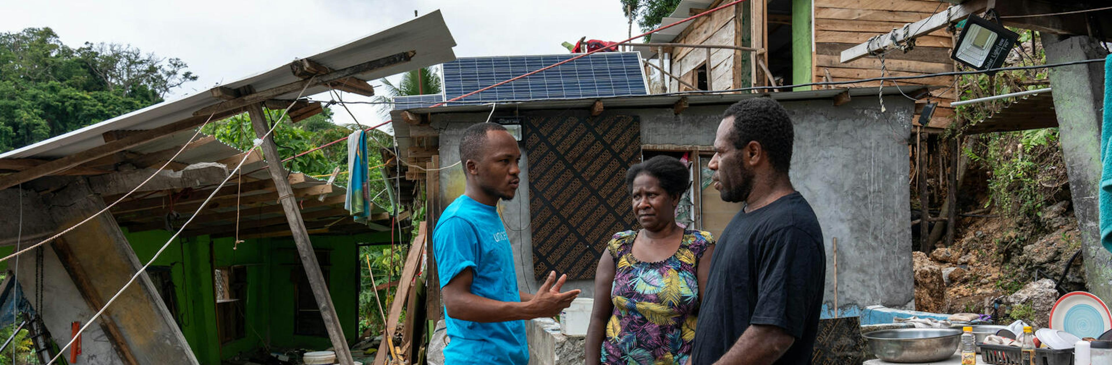 UNICEF Vanuatu WASH engineer Dalitso with father Philip and his wife Rose discussing the devestation to their home in Mele Maat Village after the Earthquake. Mele Matt, Efate, SHEFA, Vanuatu