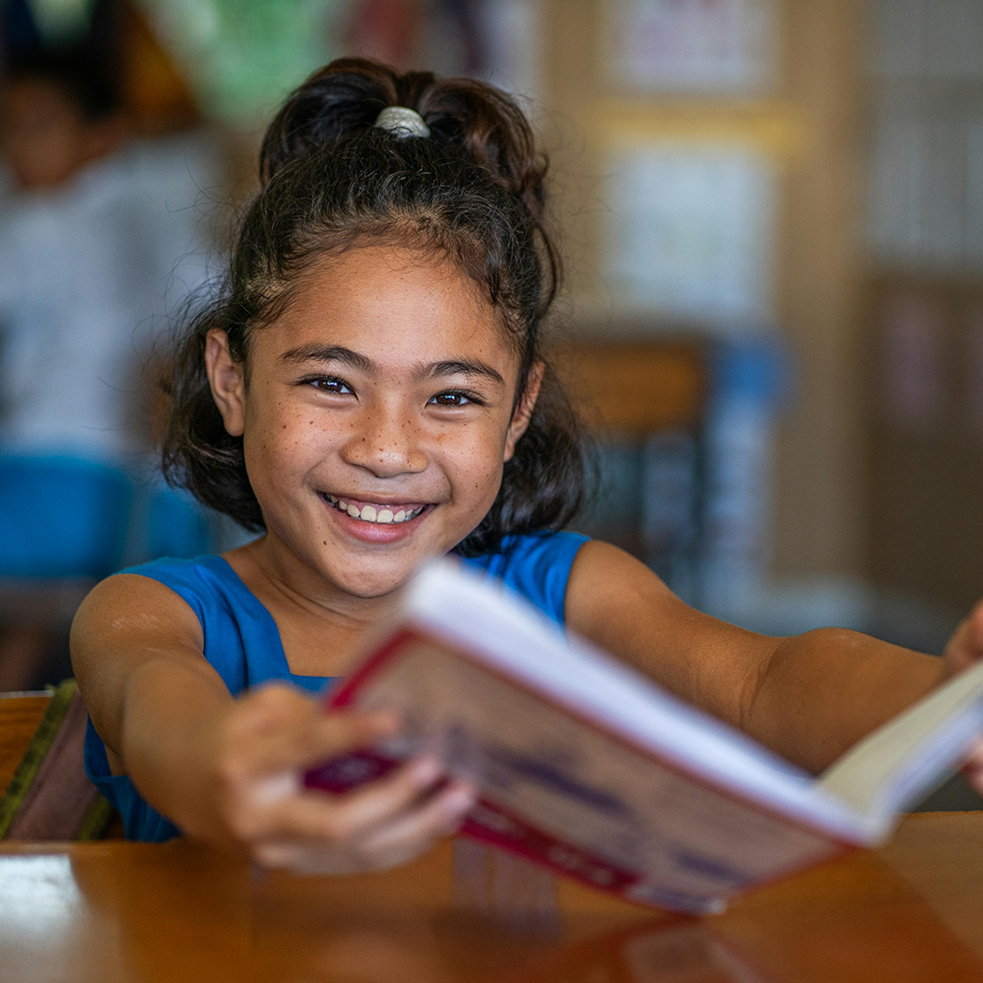 On the 29th of August, Tina from Vaimoso Primary School in Apia, Samoa, smiles during her class as she engaged in learning.