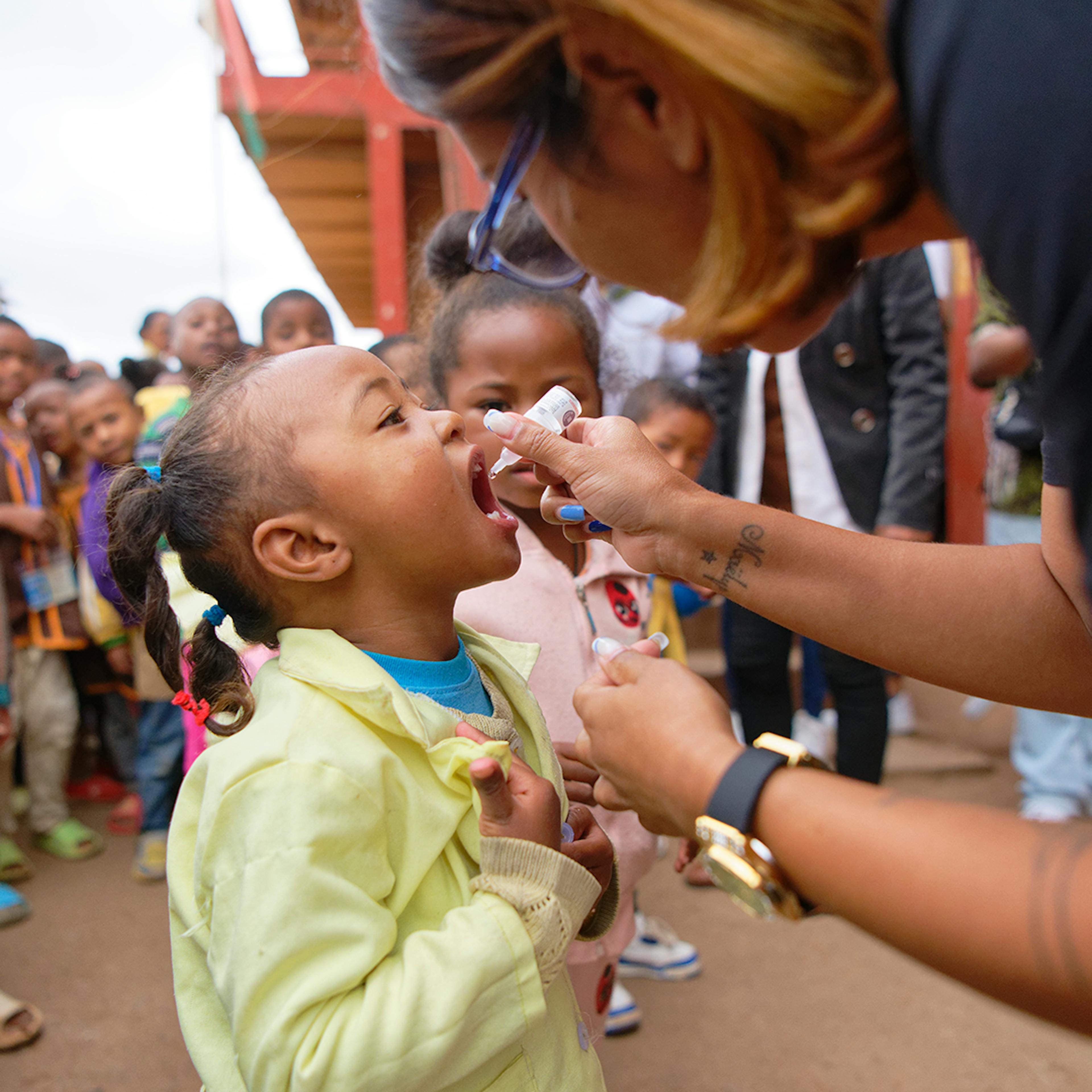 Tanjombato Primary Public School, Antananarivo  Atsimondrano  District, Analamanga Region, Madagascar (17/05/2024) : Lorah Gasy, influencer and supporter of children's rights for UNICEF giving an oral vaccine to a schoolgirl during the last day of the polio campaign.