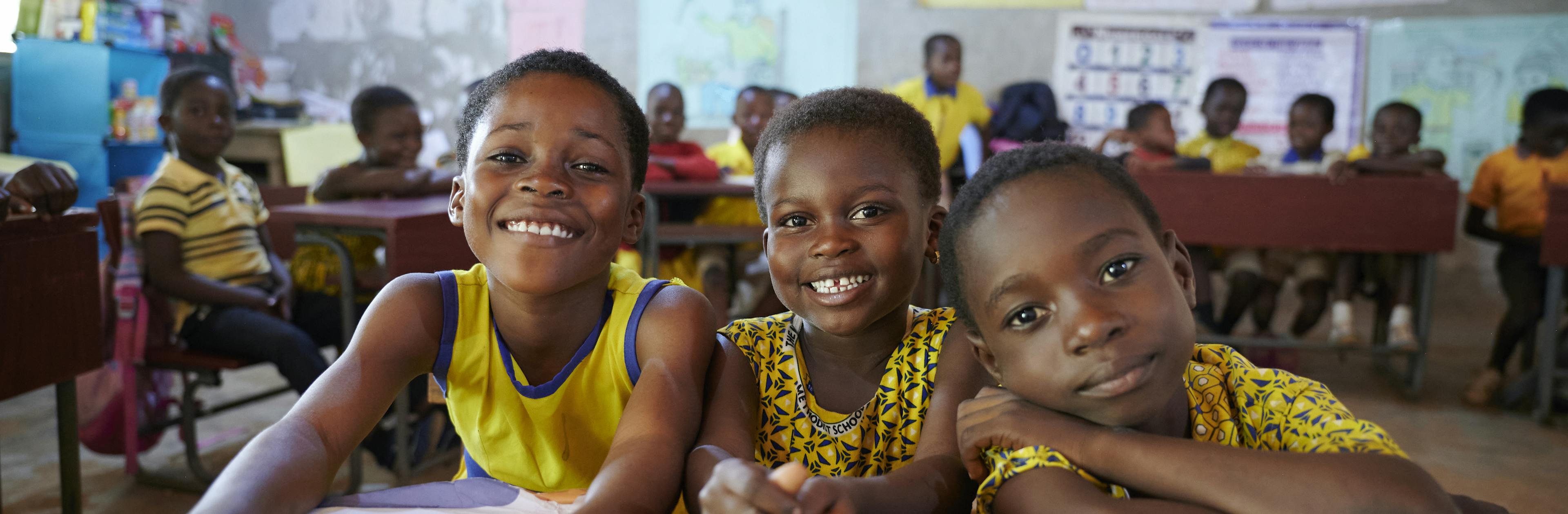 Children smile sitting in Ms. Lydia Ataa Asor’s math class where she uses Pedagogy method of teaching and employ local materials and resources to keep learning animated and interesting at New Bomfa Methodist Basic School in Juaben Municipality in Ashanti Region in Ghana. West Africa.