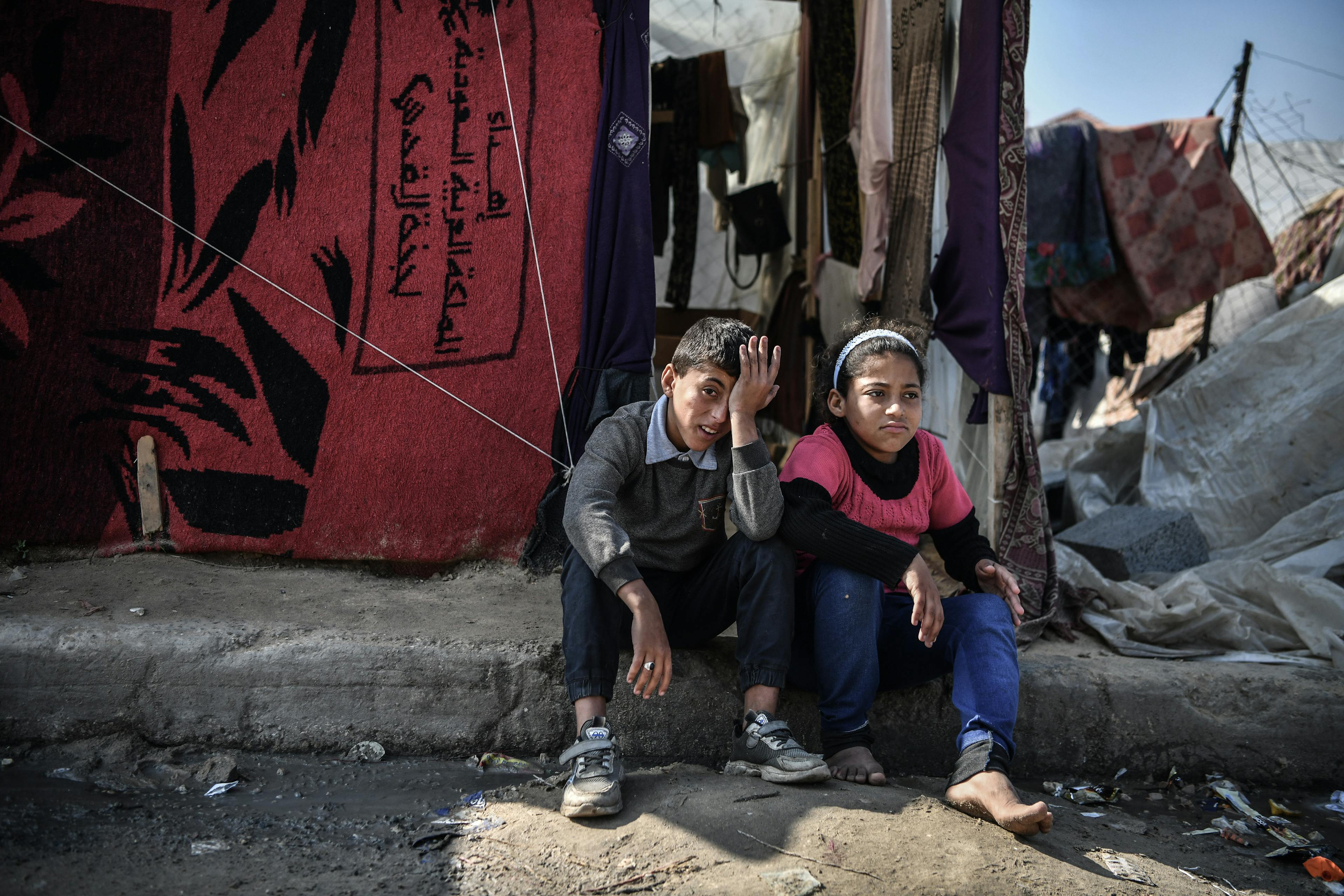 Muhammad, 11year-old, is sitting with his sister, Hala, 12 years old, in front of their tent in Rafah, south of the Gaza Strip.