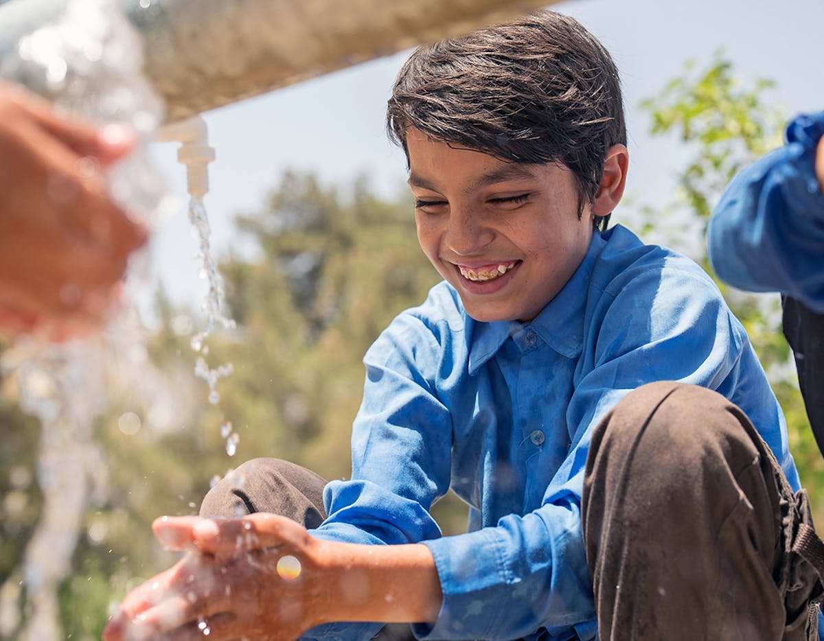 On 15th June 2023, 12 year old Mir Haq washes his hands at Mawlana Jalaluddin Mohammad Balkhi School in Mazar-i-Sharīf, Balkh Province, Afghanistan.