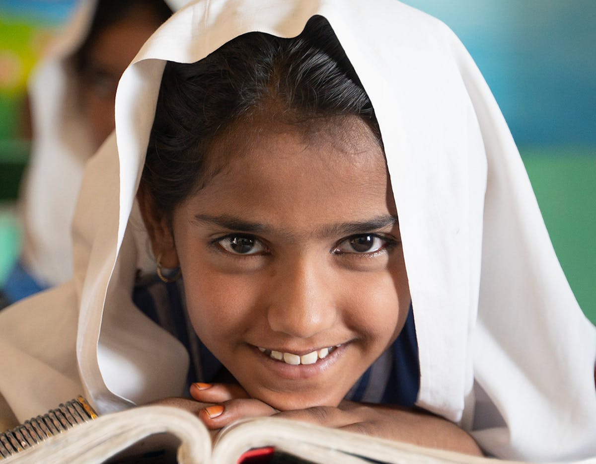 Rehana, 7 years old, poses for the camera, expressing pure joy and happiness for being in school in Basti Shahnawaz, District Rajanpur, Punjab.