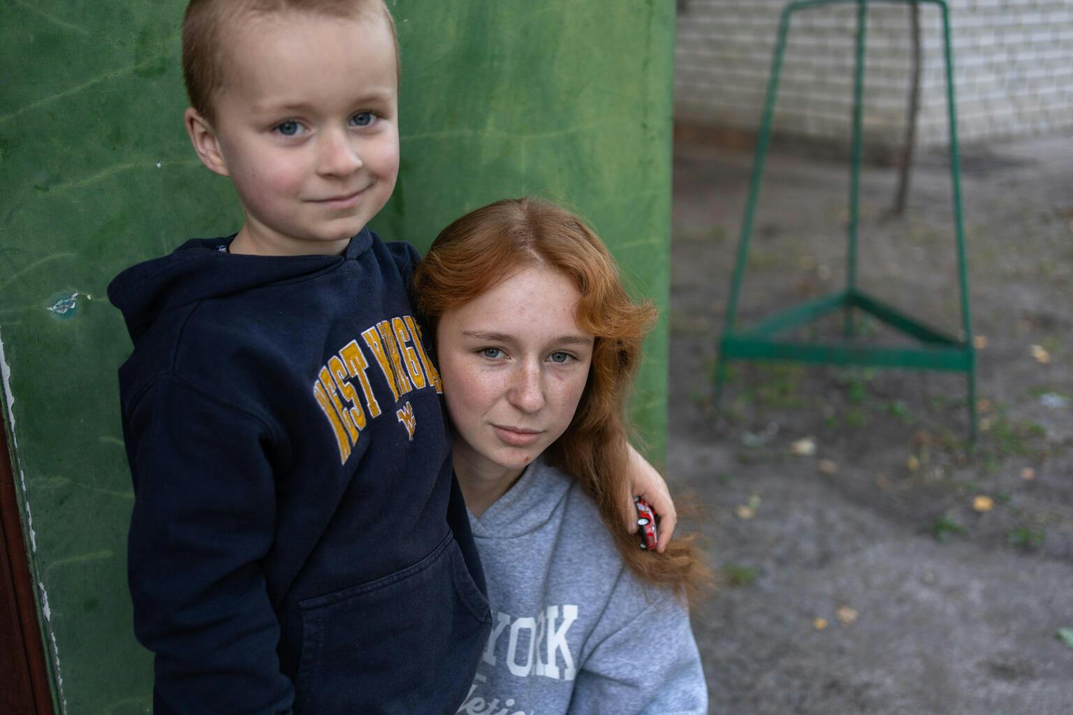 Siblings, Halia (14) and Andriy (5) share a hug after being displaced from their home after fighting erupted in Vovchansk, Ukraine.