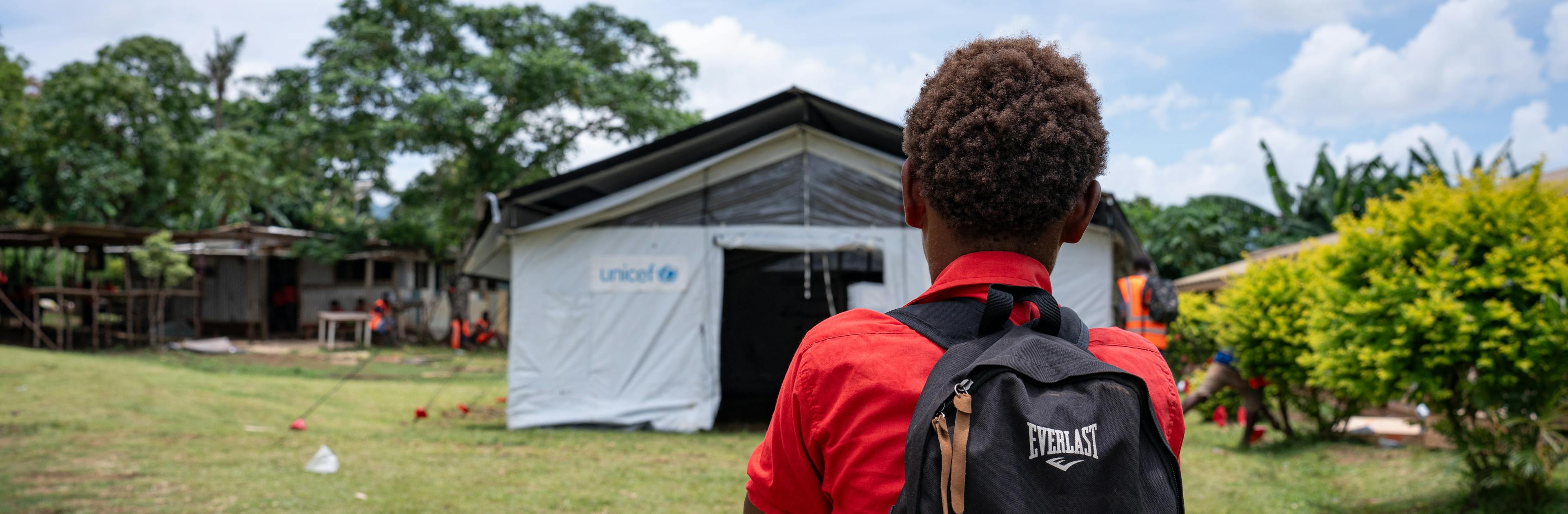 A student from Survival School inspects a tent set up by UNICEF staff and Red Cross volunteers as a temporary classroom after the December 17th earthquake damaged the school's buildings at Fresh Water Five, Efate, SHEFA, Vanuatu.