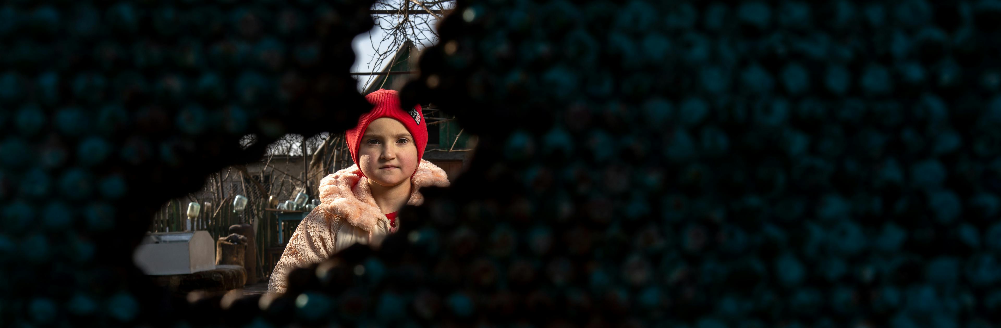 Alina, 12, stands next to her home, scarred by shrapnel in the village of Kobzartsi, Mykolaiv region, which suffered heavy damage during the early days of the full-scale war in Ukraine.