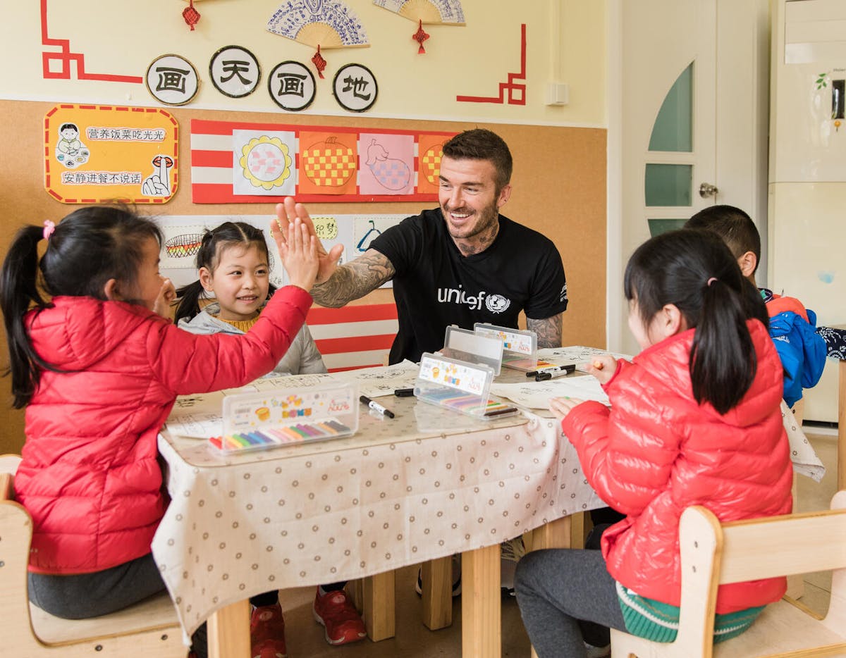 UNICEF Goodwill Ambassador David Beckham high fives with a girl during a visit to Xianghuaqiao Kindergarten on the outskirts of Shanghai, China
