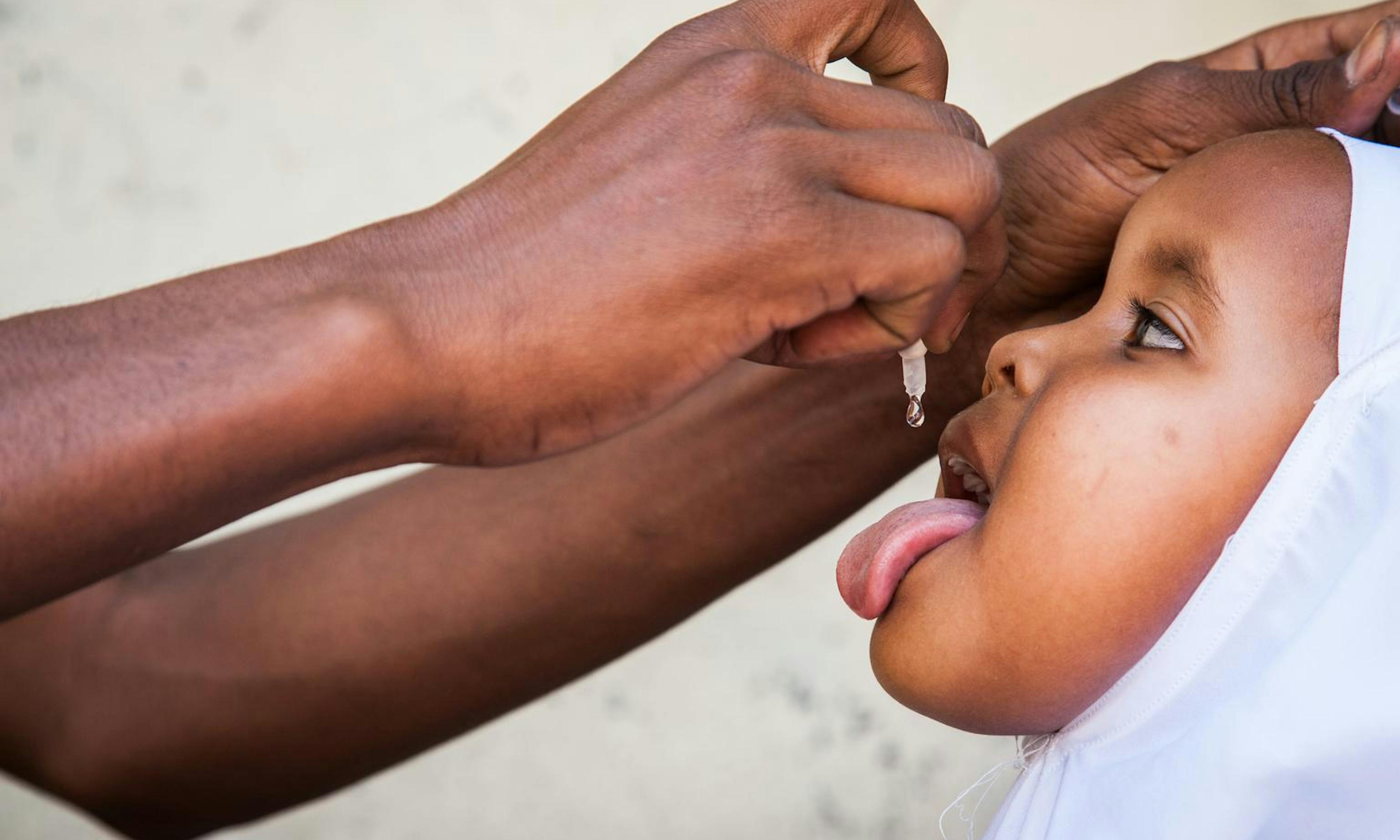 In Somalia, a girl receives a dose of oral polio vaccine at Daalo First School, during an emergency polio immunisation campaign in the city of Hargeisa