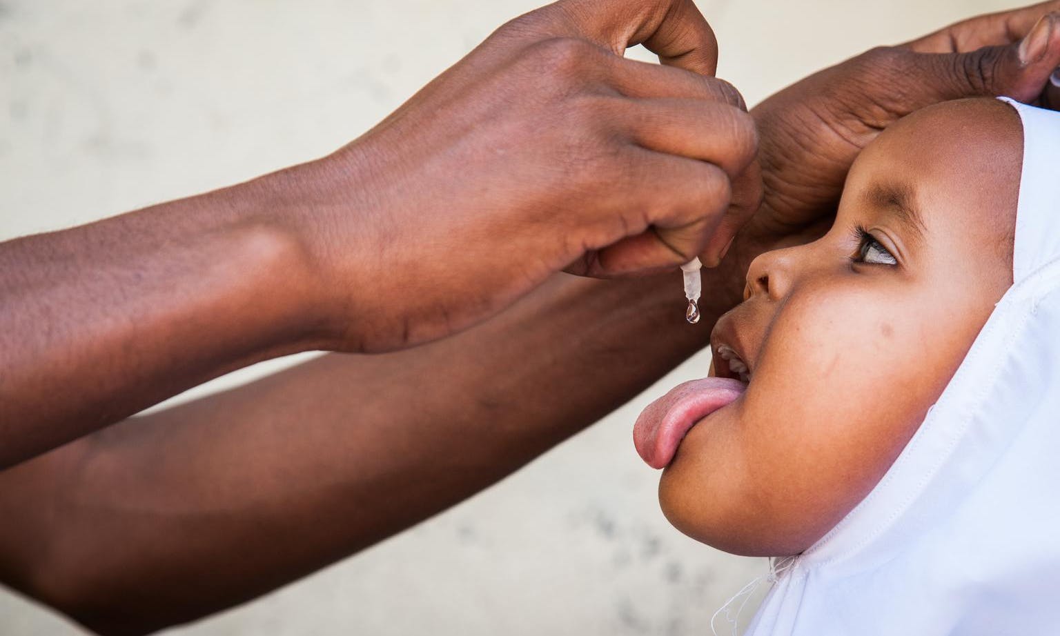 In Somalia, a girl receives a dose of oral polio vaccine at Daalo First School, during an emergency polio immunisation campaign in the city of Hargeisa