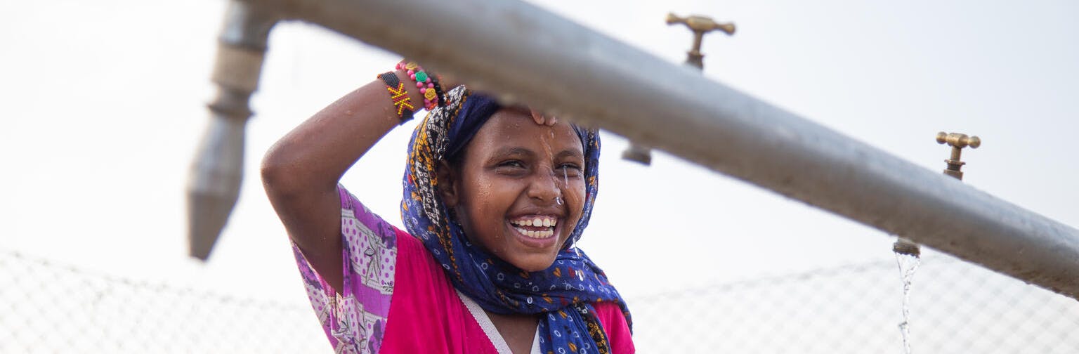 7-year-old Madina Mohamed Awad collects water at a new water station in the small village of Gelhanty in the Red Sea state, Sudan.