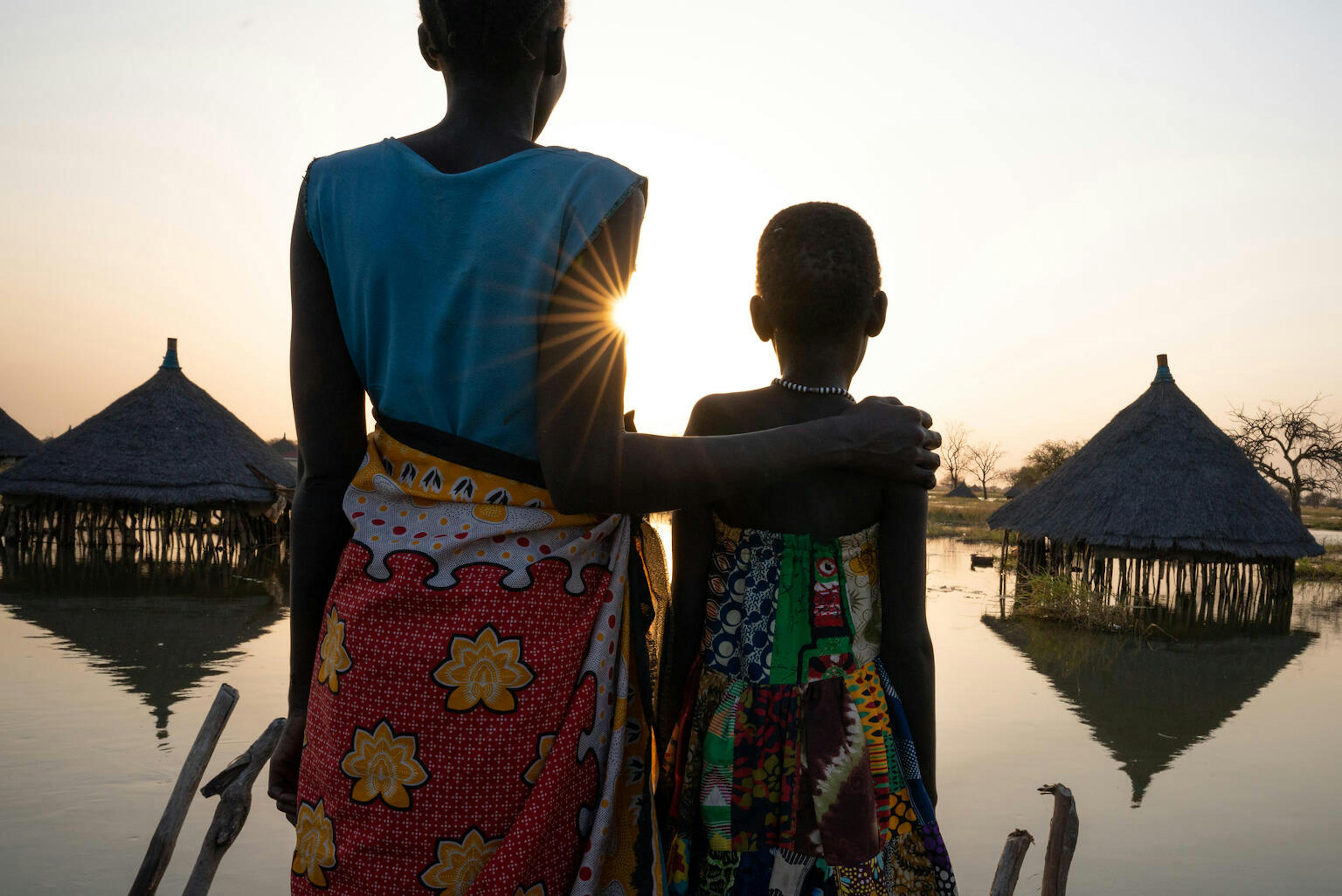 A mother and daughter look out over submerged houses in Jonglei State, South Sudan. 