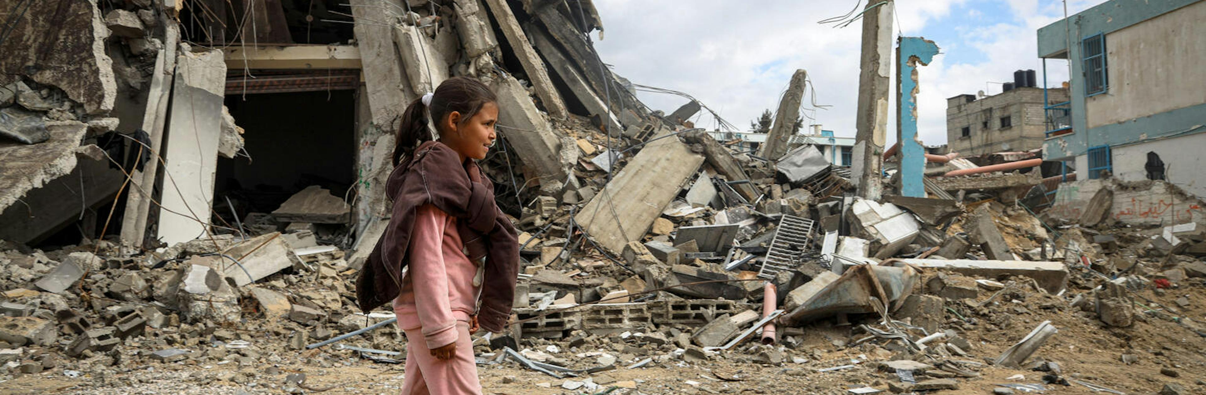 Sama 10-year-old walks through the rubble of her destroyed neighborhood in Khan Younis, southern the Gaza Strip.