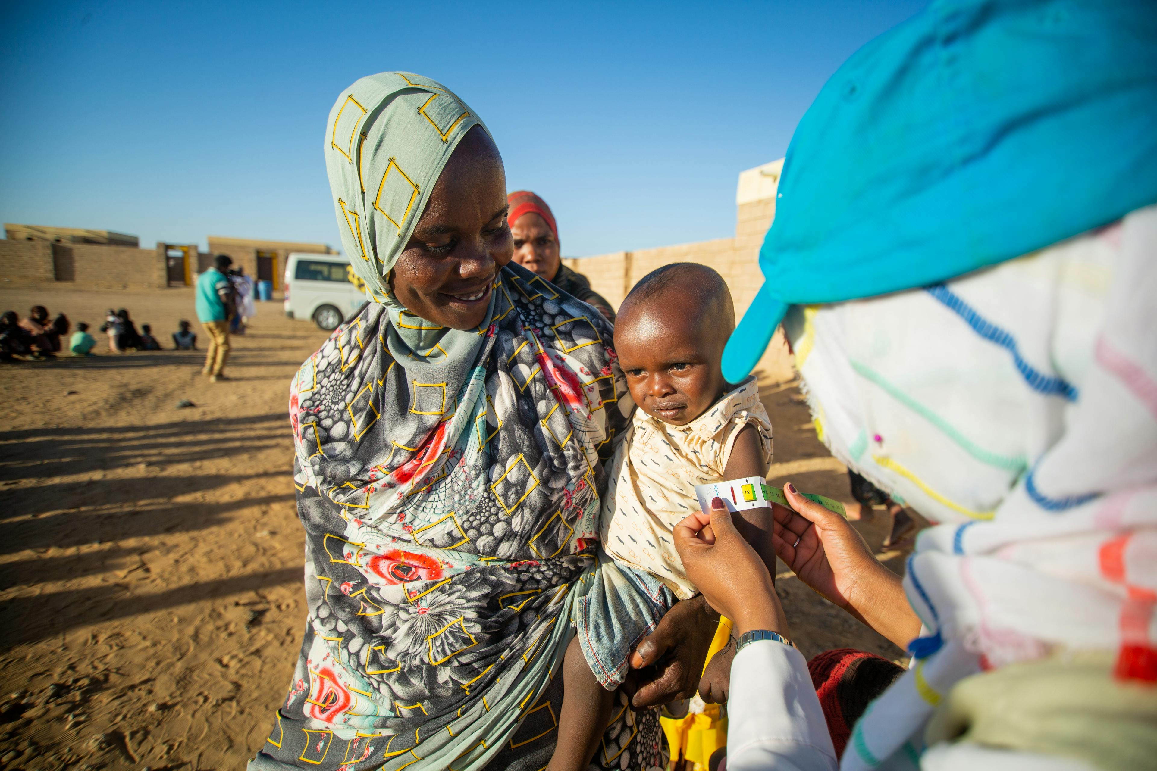 Displaced children are screened for malnutrition during the UNICEF integrated health, nutrition, and WASH campaign at Alnahda gathering point, River Nile state.