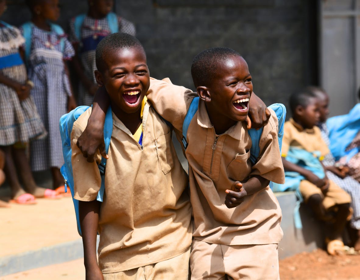 Children at the playground of their school made out of recycled plastic bricks.