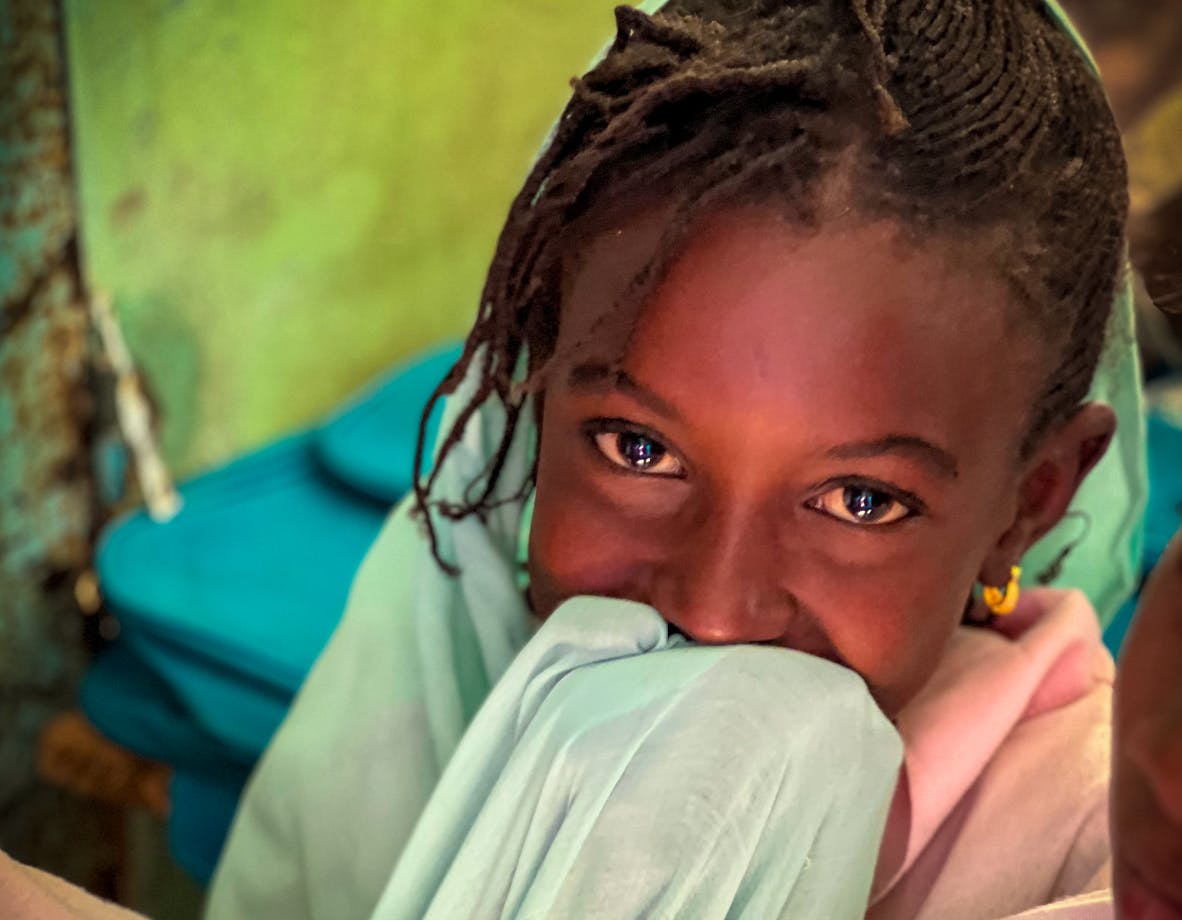 A young girl from Mauritania smiling.