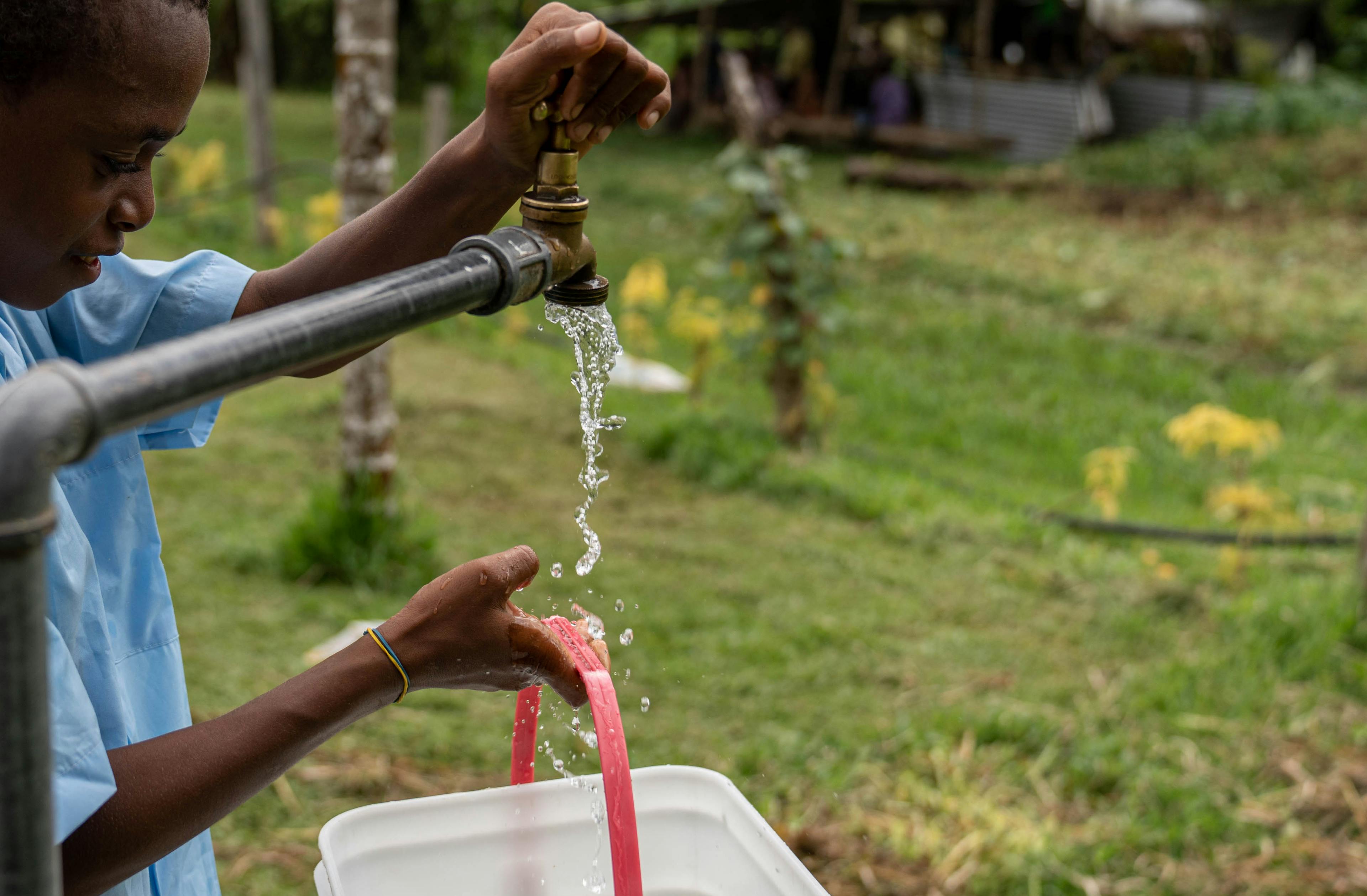 Students of Bangabulu school collecting water from an improved source at their school. Red Cliff, South Ambae, PENAMA, Vanuatu