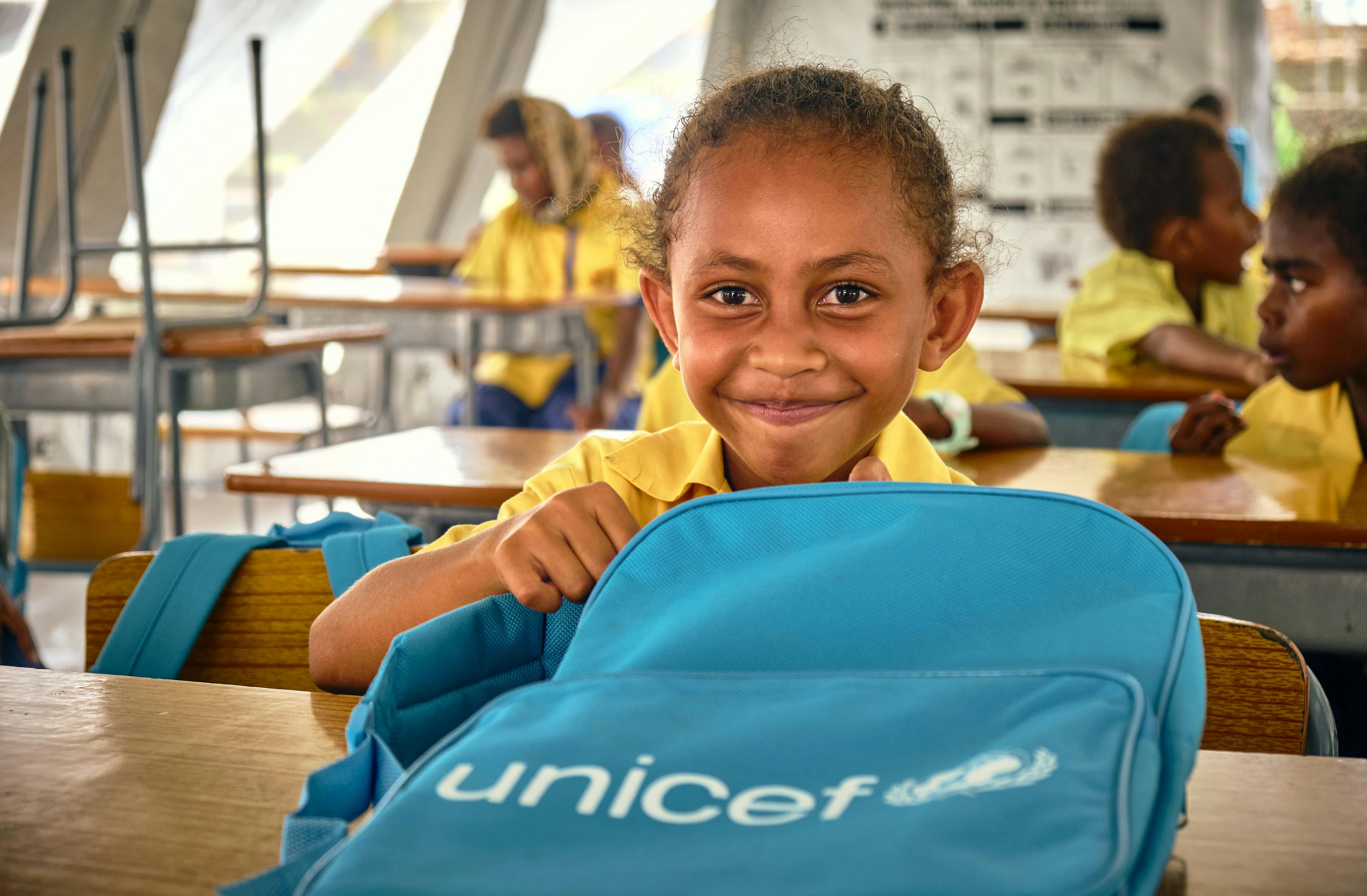 Keziah Vatoko (7 yrs) who is in class 3 at École Publique Centre Ville is excited to open her UNICEF backpack. "I am happy to be back in school and to meet my friends" says Keziah.