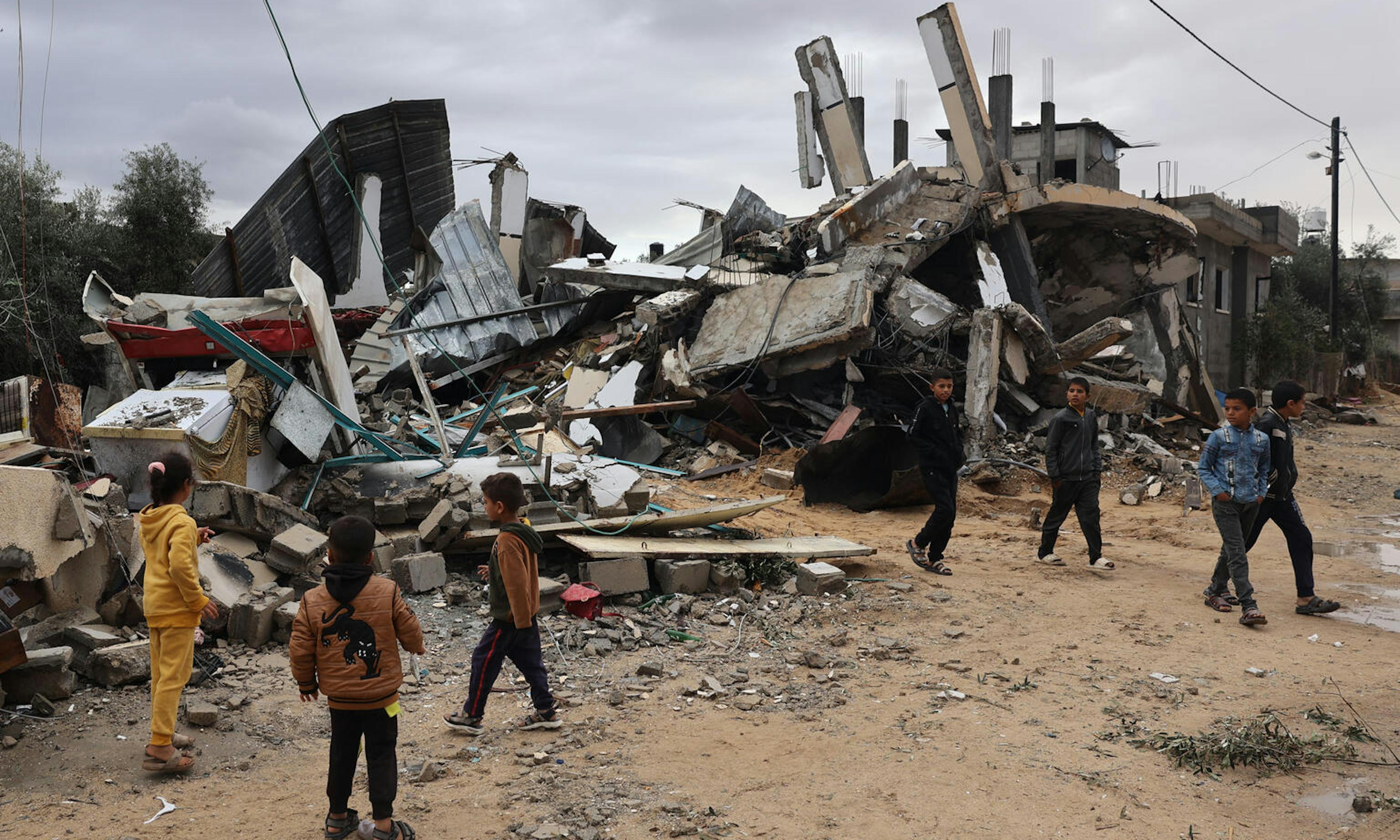children in Gaza congregating in front of rubble