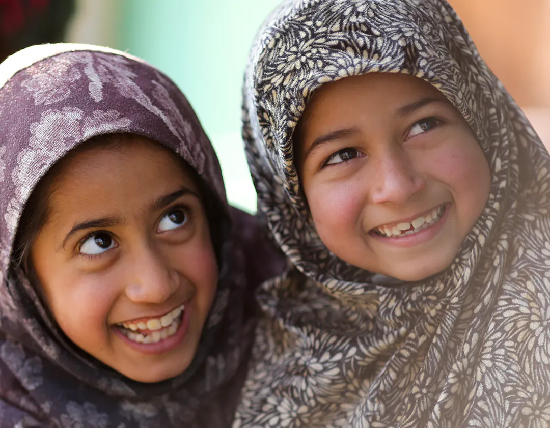 Uzmat Mushtaq and Ayat Jameel smile during a Home Based Learning (HBL) or (Angan Shala) program in Cherdari village of district Baramulla, Kashmir. HBL or (Angan Shala) is a home based stimulation module that aims to capacitate and involve parents to avail children stimulation for all round development.