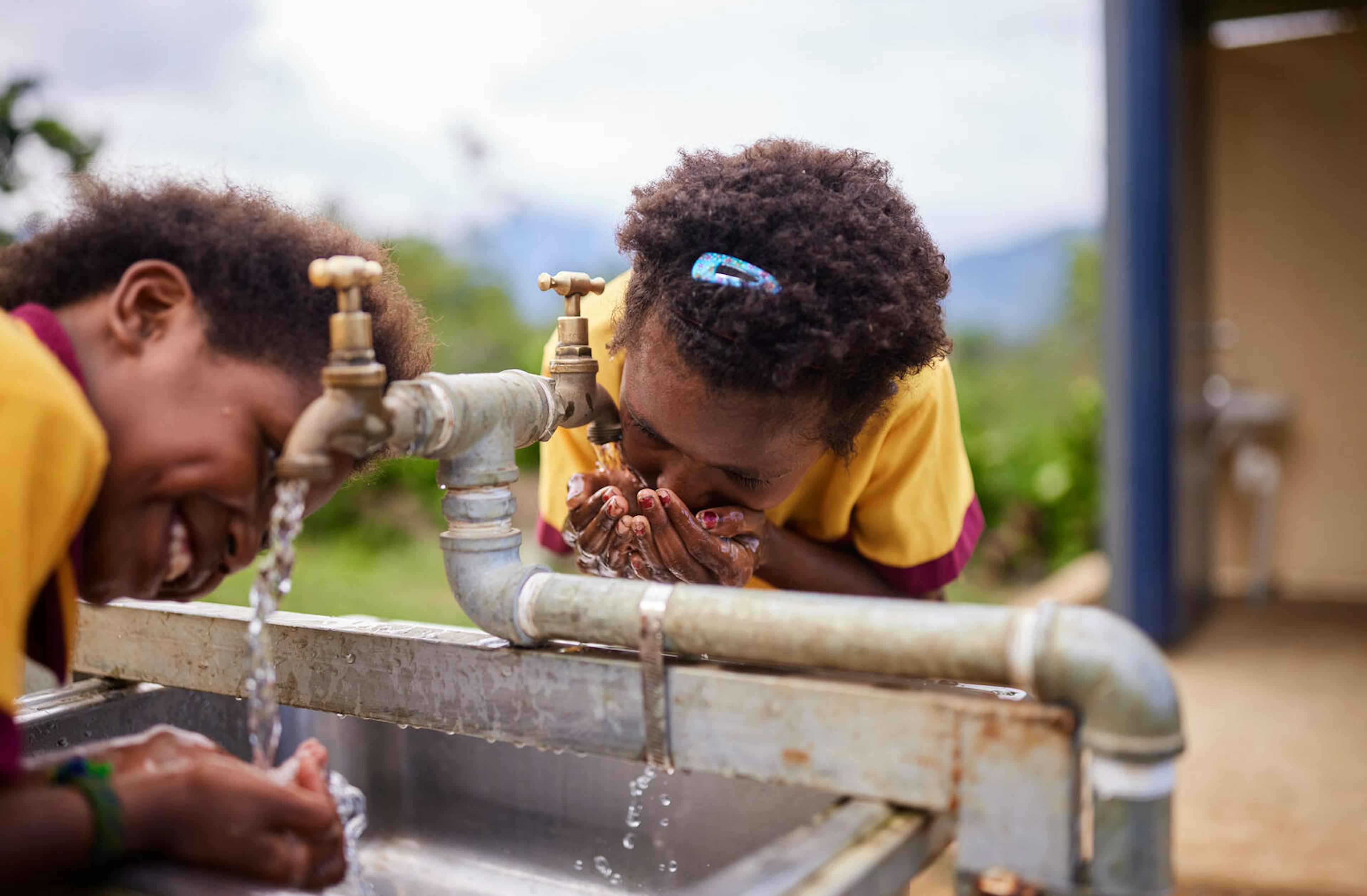 Haylie (9yo) and Patricia (8 yo) using the new WASH facilities at their school in a remote mountain village in the Morobe Province of Papua New Guinea. The new WASH facilities, which include a rainwater tank, two handwashing stations and two toilets, were installed in 2022 as part of UNICEF’s Convergence program.