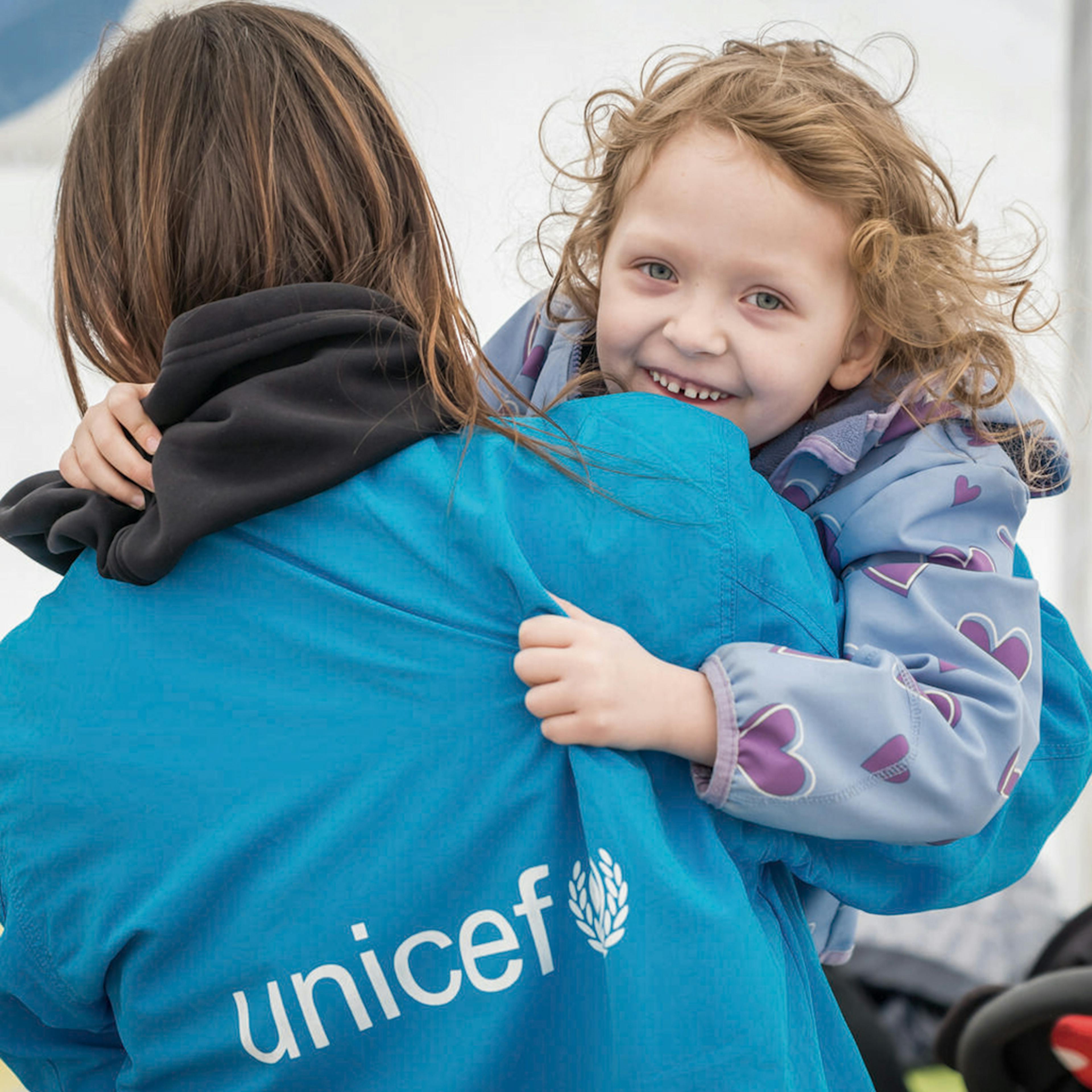 On 7 April 2022 at a Blue Dot hub in Isaccea border crossing, Romania, 5-year-old Emma plays with a UNICEF staff member. Emma, her mother Yulia, and her little brother arrived at the hub after traveling from Odessa, Ukraine.