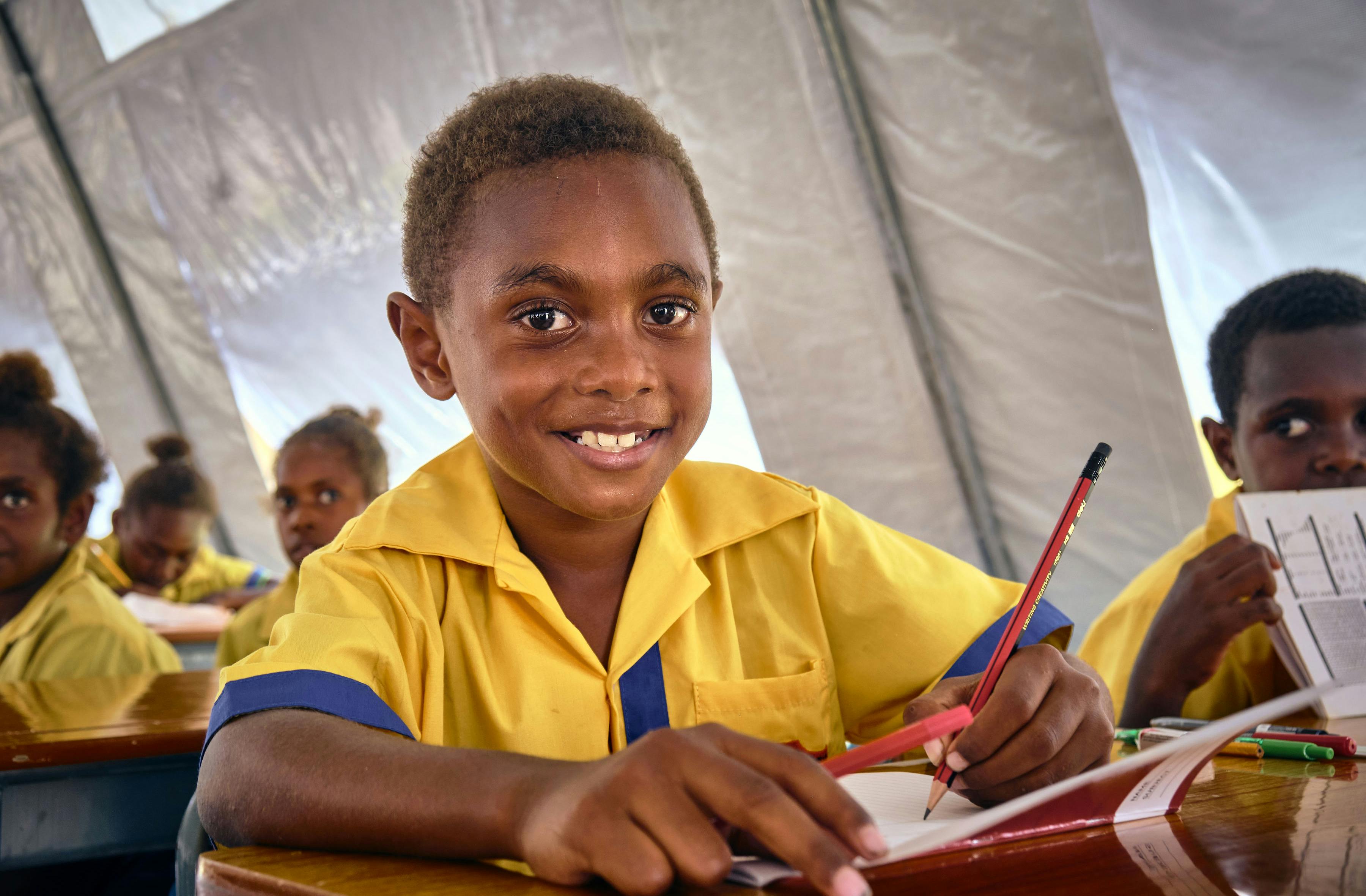 8-year-old Phills Liu says that he loves to learn how to write. Here he is using stationaries that came with the UNICEF backpacks. He is in class 3 at École Publique Centre Ville.