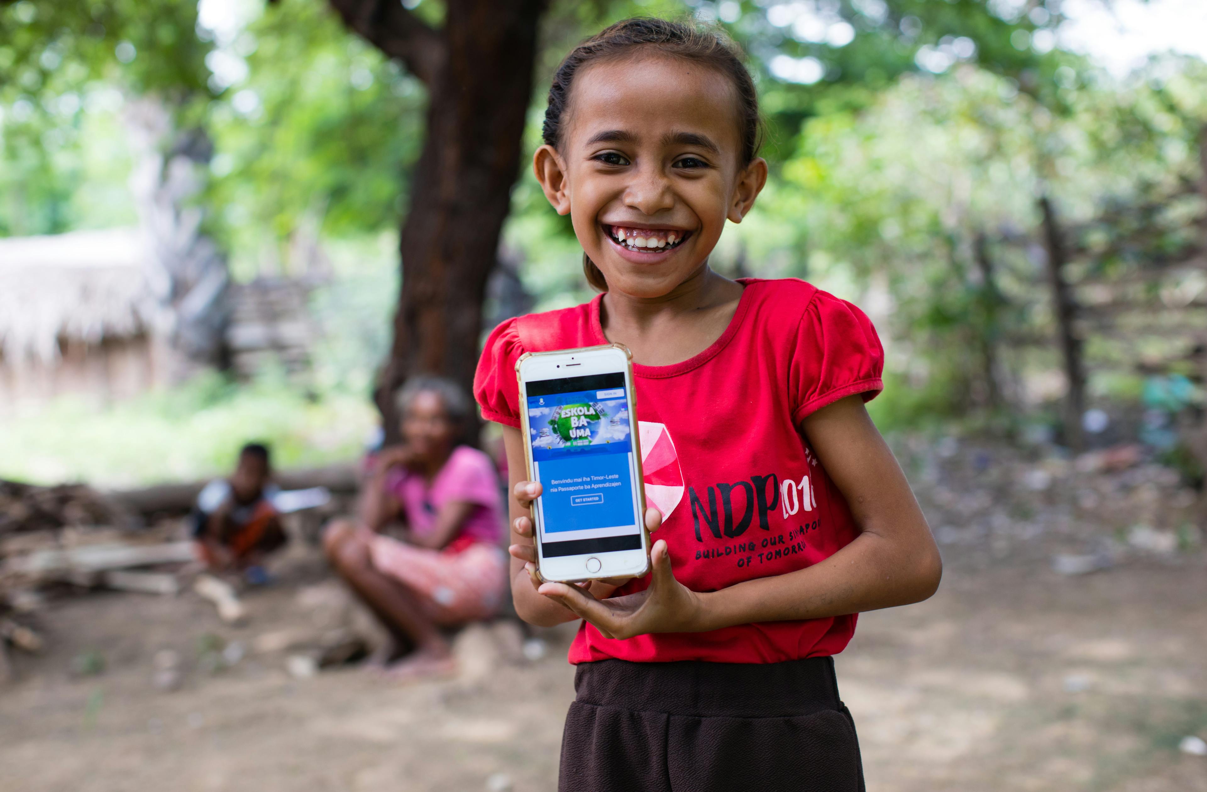 A girl shows off the online platform on which children and parents in Timor-Leste can access a range of audio-visual material to help students continue learning during ongoing school closures.