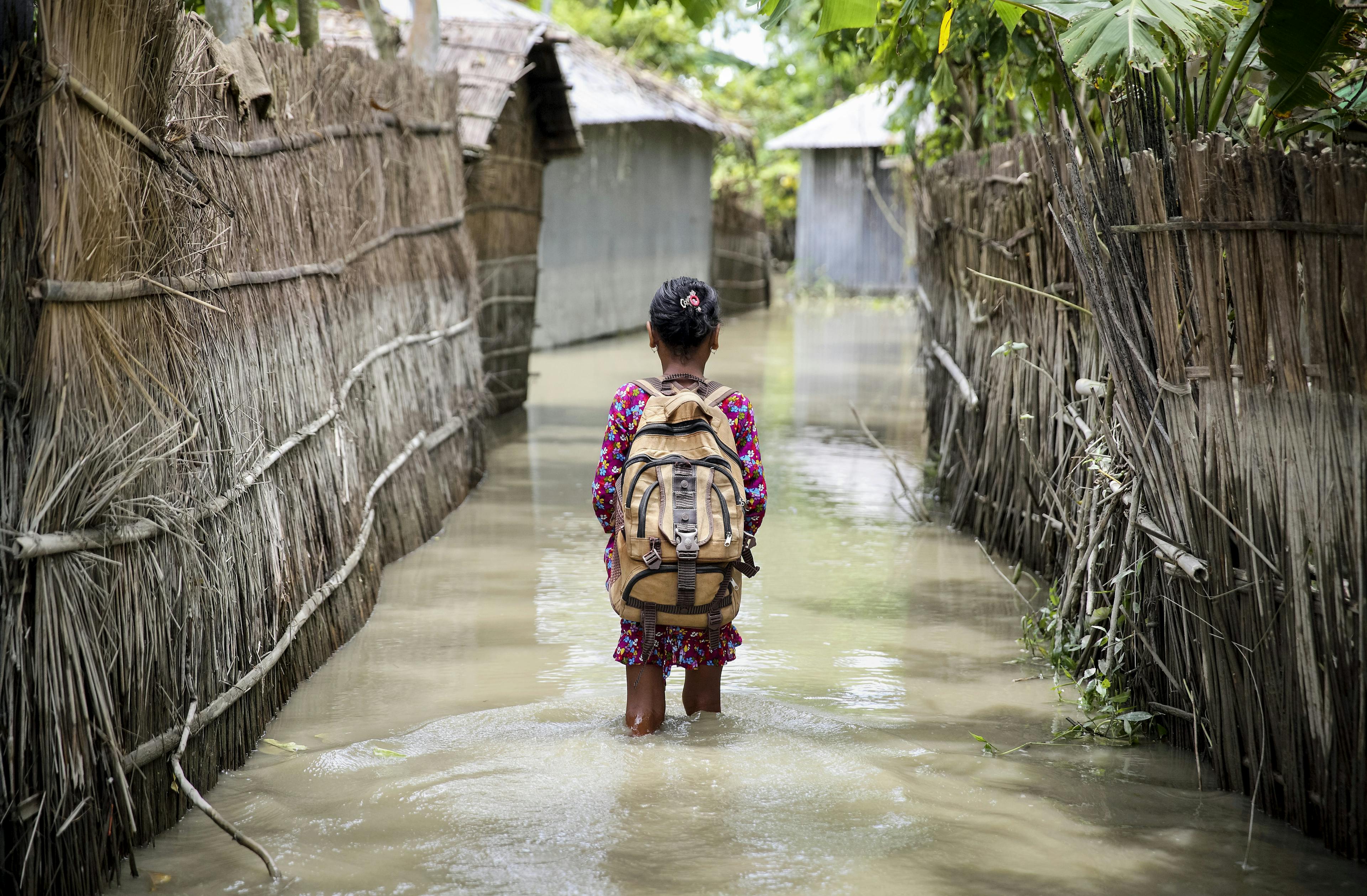 A child wades through water on her way to school in Kurigram district of northern Bangladesh.