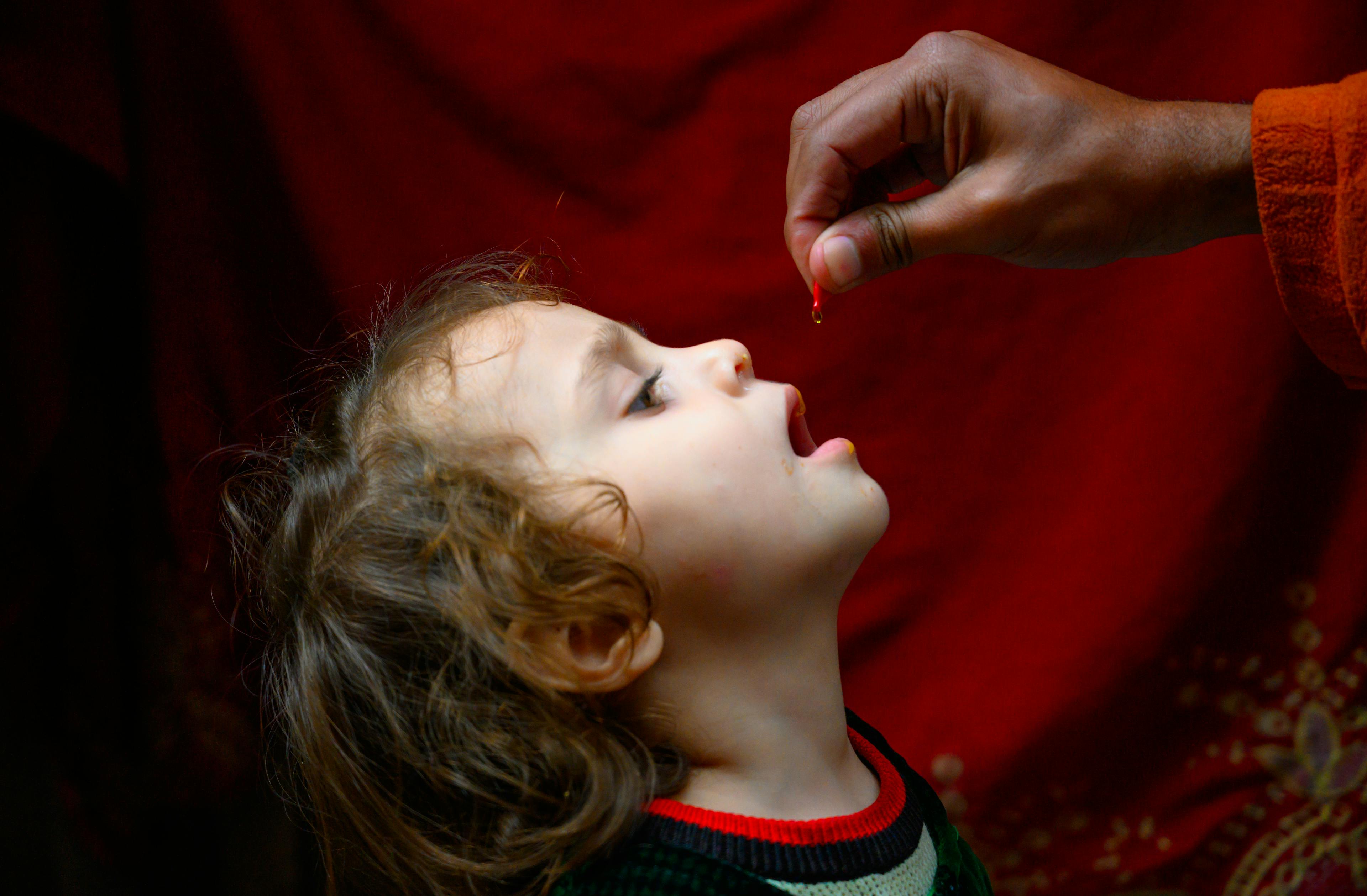 A four year old girl receives Vitamin A form Ajmal, a polio vaccinator in Lahore during Pakistan's first national campaign of the year, aiming to vaccinate over 40 million children under five year of age against polio and provide Vitamin A supplementation.